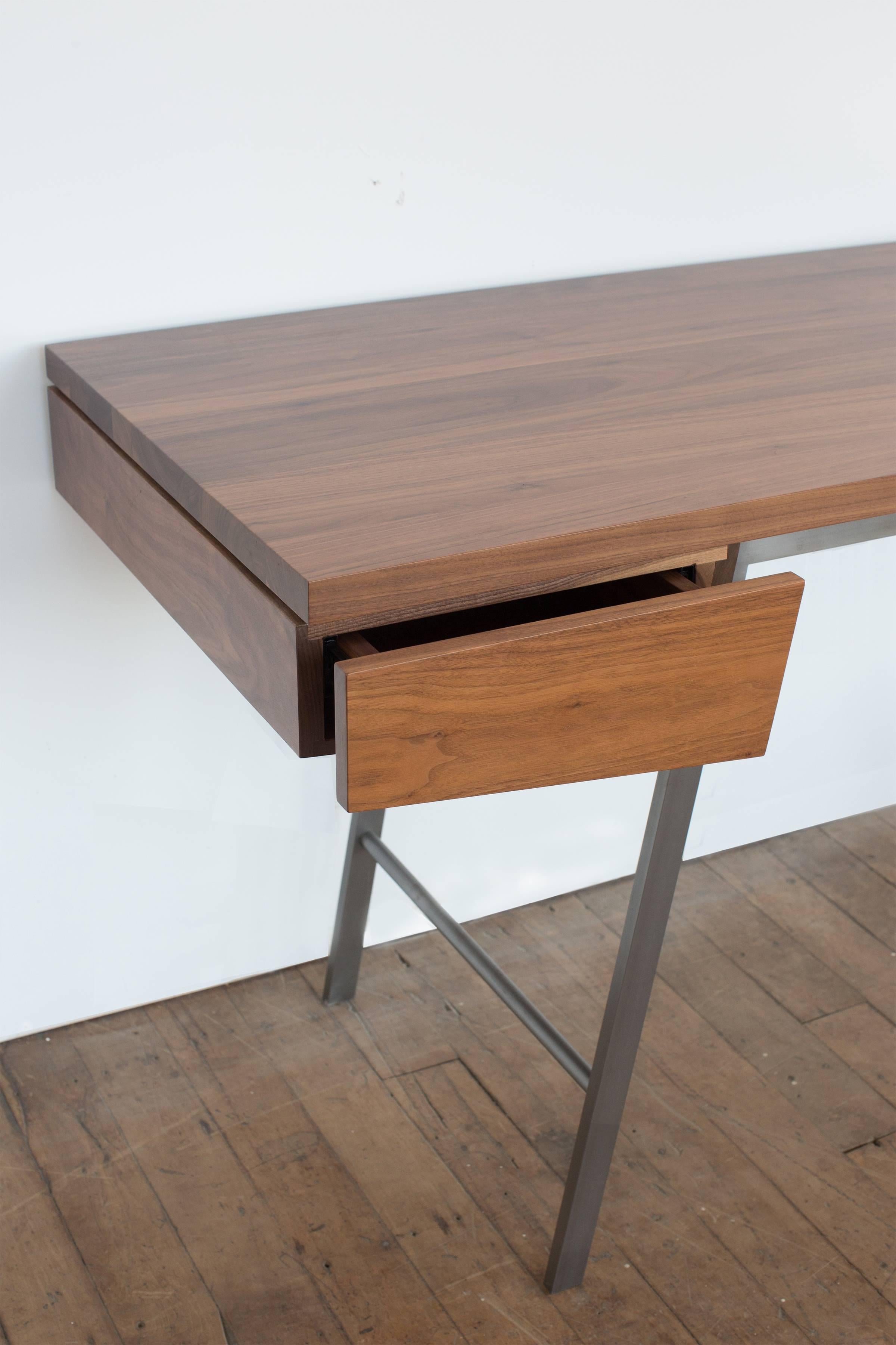Spare, refined, and meticulously handcrafted of solid hardwoods and bronze, the AD7 desk is distinguished by superb detailing, the finest materials and timeless design. The composition plays with the relationship between positive and negative space,
