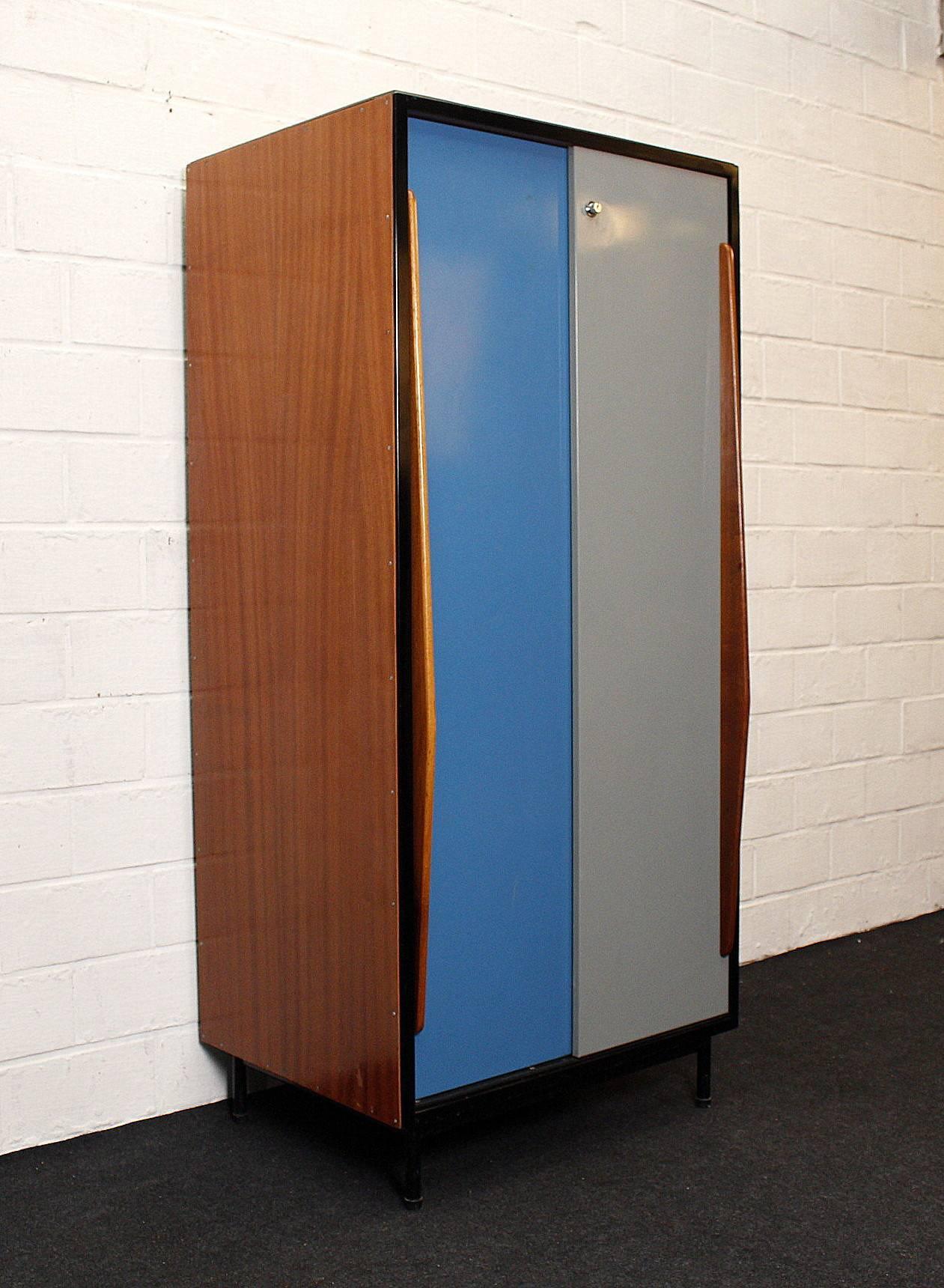 Wardrobe by designer Willy Van Der Meeren for Tubax.
Is made of colored gray and blue metal doors and wooden handles.
Is in very good vintage. Only a small professional restoration bottom left (see picture).

Van Der Meeren is considered one of