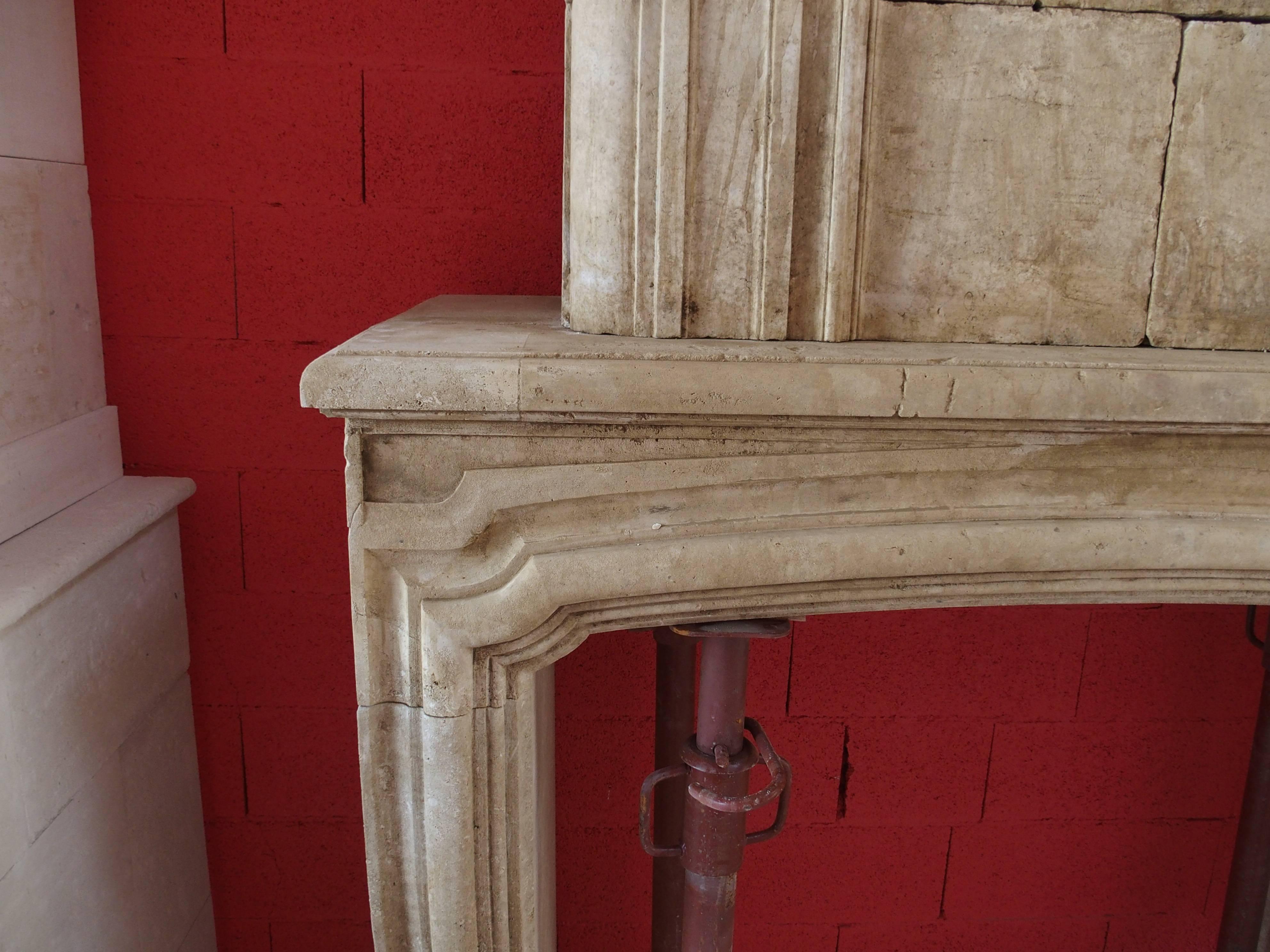 This exceptional 18th century fireplace with trumeau was carved into a natural French limestone.

The lower part of this antique mantel consists of a pair of slightly curved jambs, a low-arched lintel and a finely molded shelf. A wide bolection
