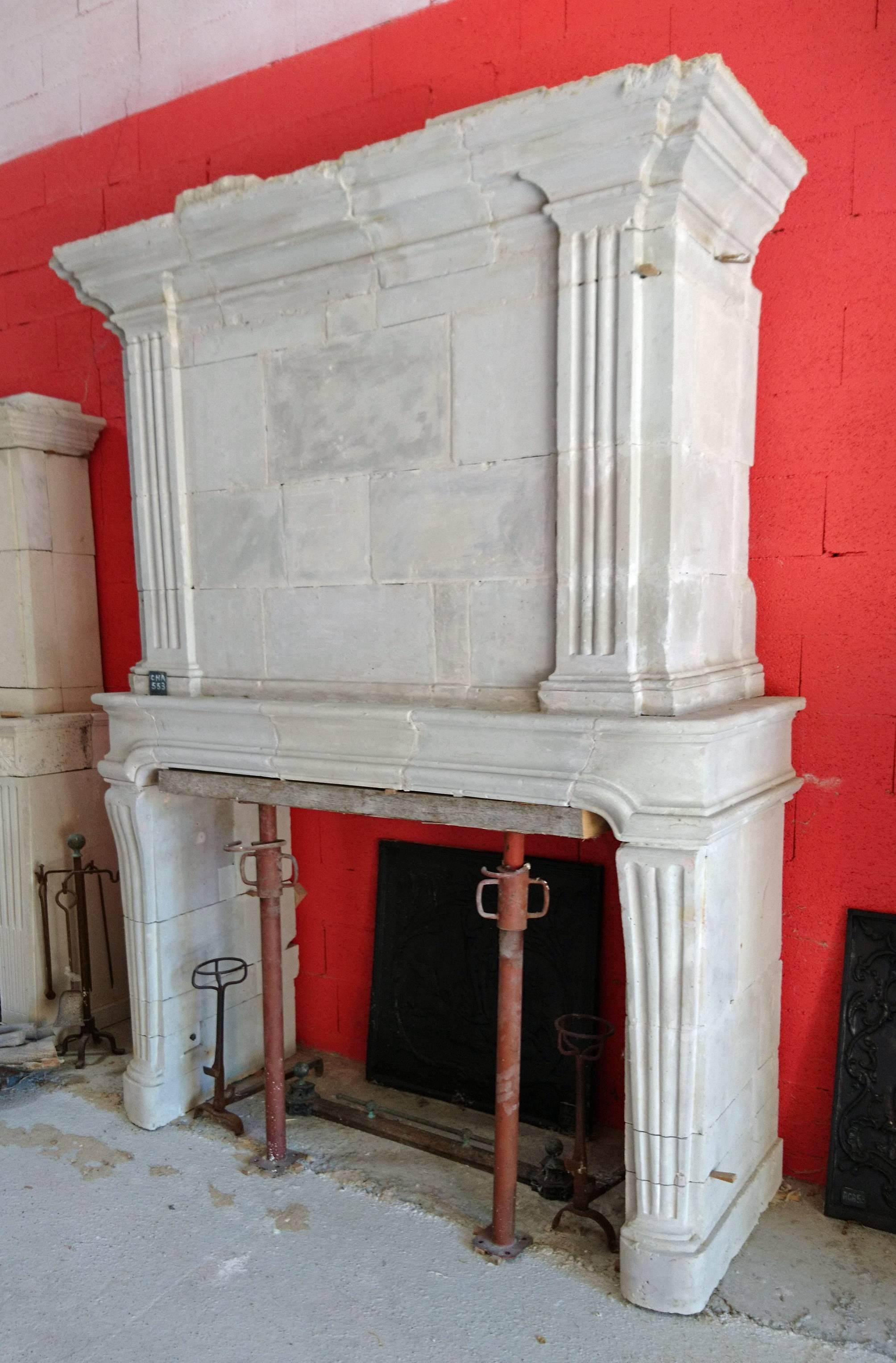 This 18th century antique fireplace with stonework trumeau was carved into a natural type of French limestone. 

The originality behind this Louis XV (1710-1774) fireplace is the slightly curved upper part of the fluted jambs. Hence, the flutes