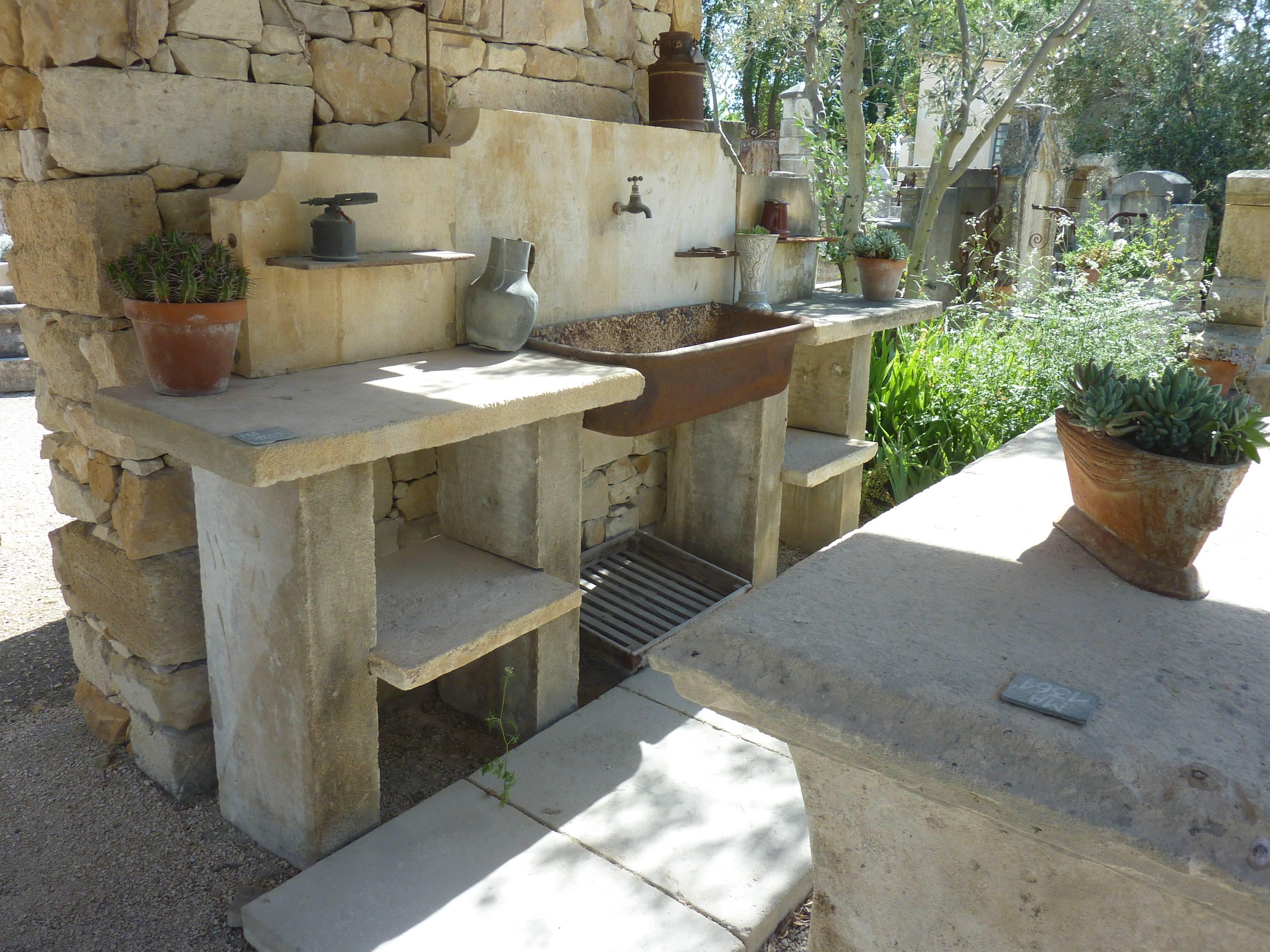 This large summer kitchen has been made entirely with authentic reclaimed materials.

It consists of as central piece, an ancient metallic trough transformed into a sink. On each side, stone working plans resting on solid jambs fitted with shelves