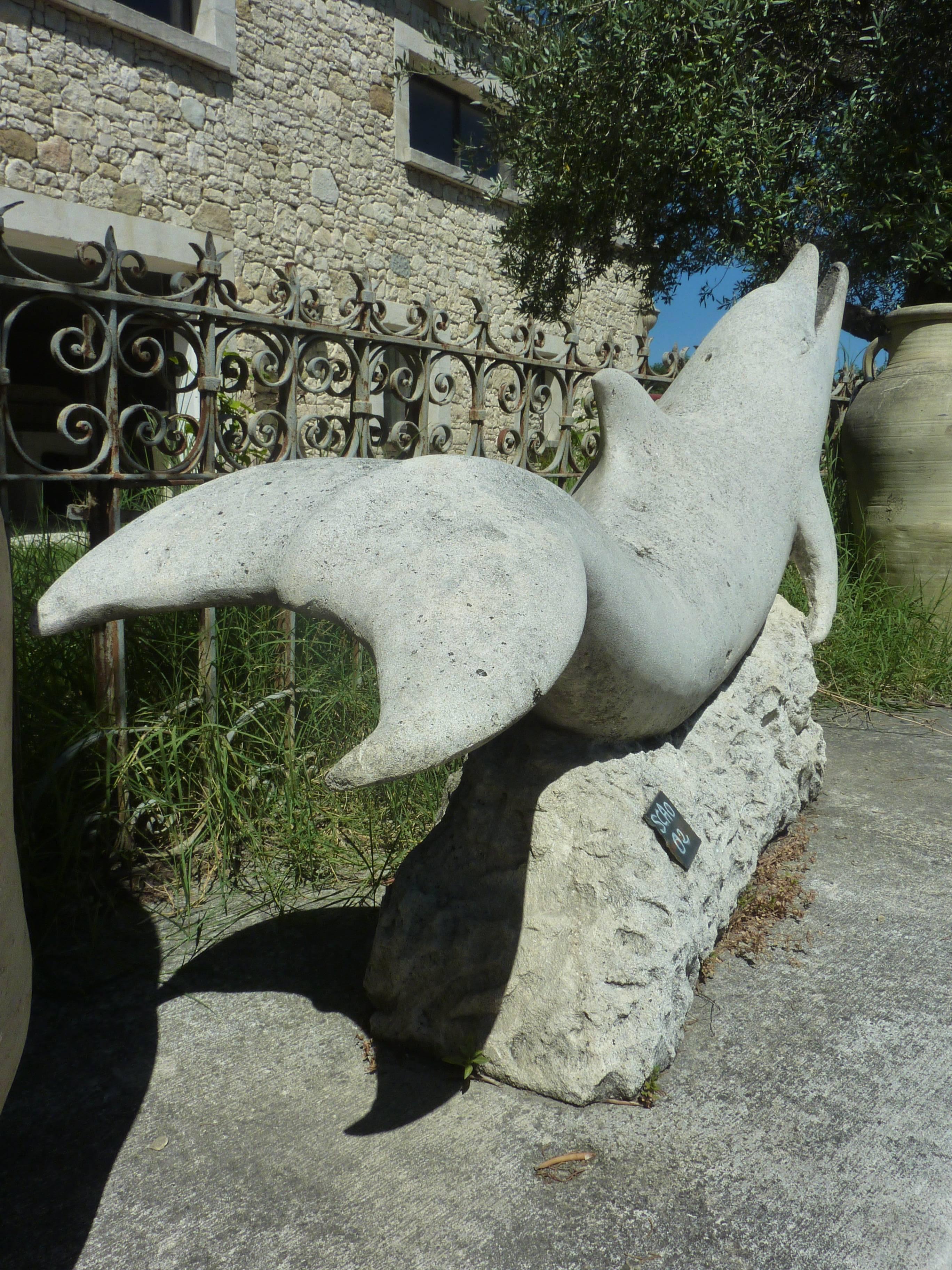 This elegant piece has fine details and a stunning patinated natural finish.

This large dolphin is resting on a solid block of stone. It has been hand-sculpted by a master stone mason into a massive block of monolithic natural French