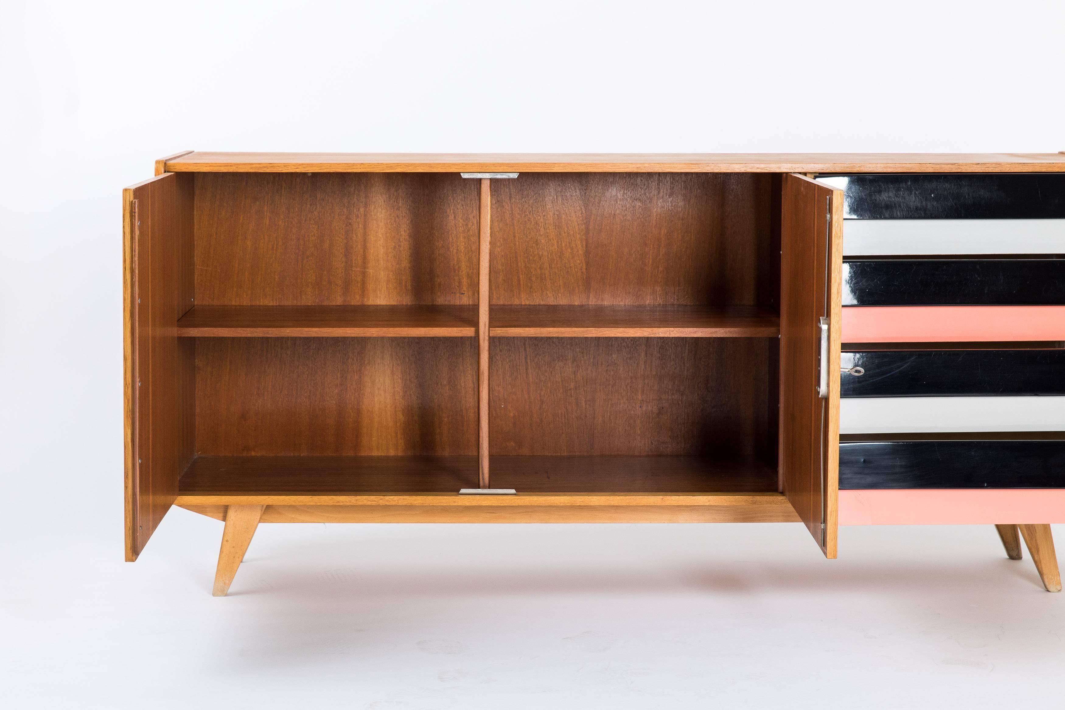 Eye-catching sideboard from the hands of Czech designer Jiri Jiroutek, Type U-460 from the stunning U-450 series designed in the late 1950s featuring the 1958 Brusel World Expo. With two revolving doors and four drawers in pink, black and off-white