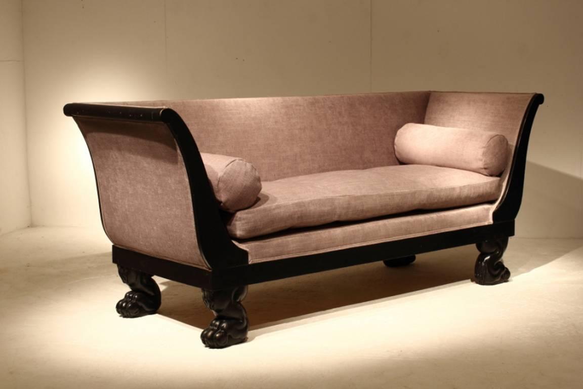 Ebonised 19th century French sofa with slender arms and paw feet, circa 1840.

 