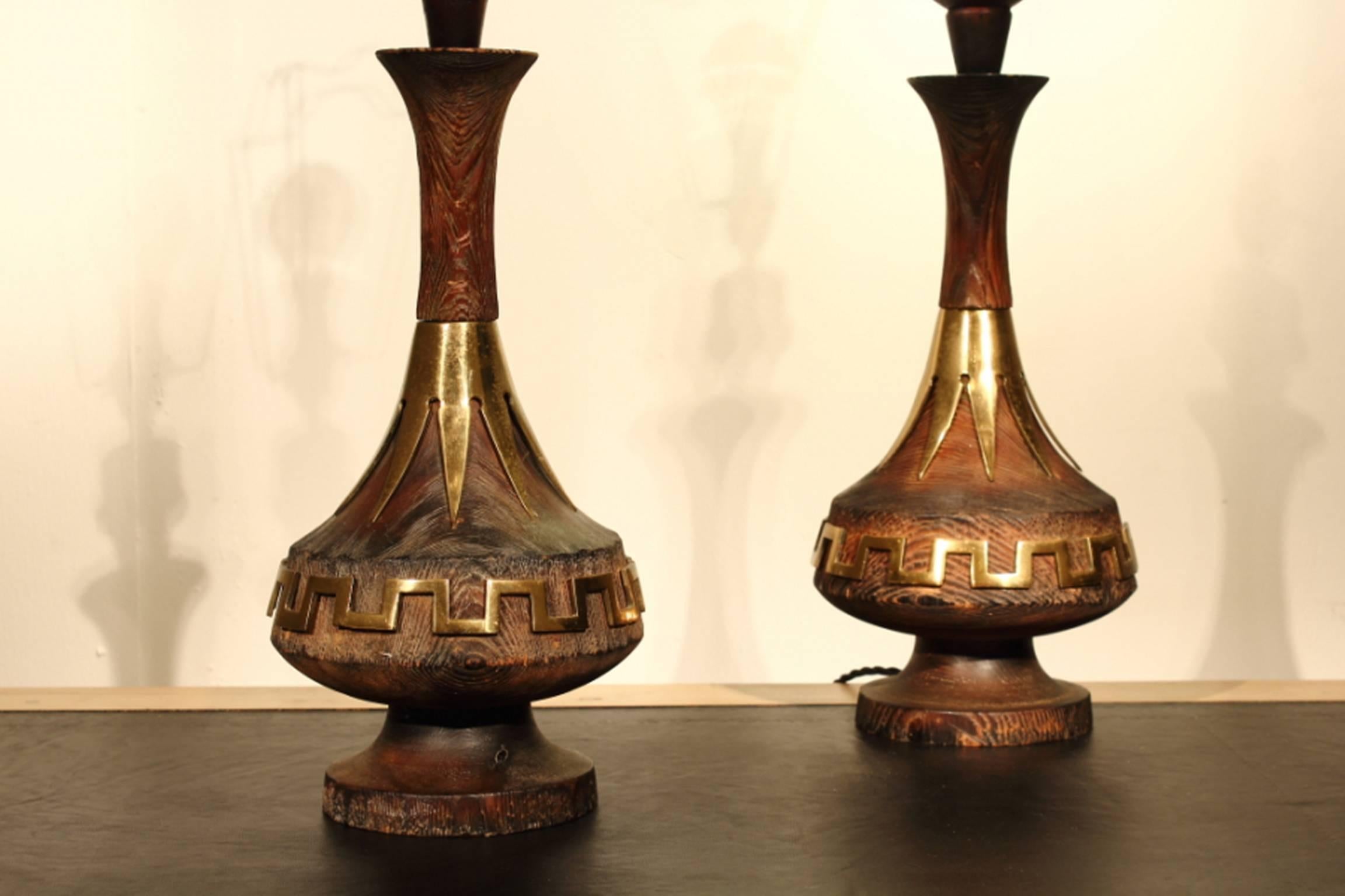 Unusual pair of 1960s wooden lamps with brass metalwork. Wood has a burnt finish .

 