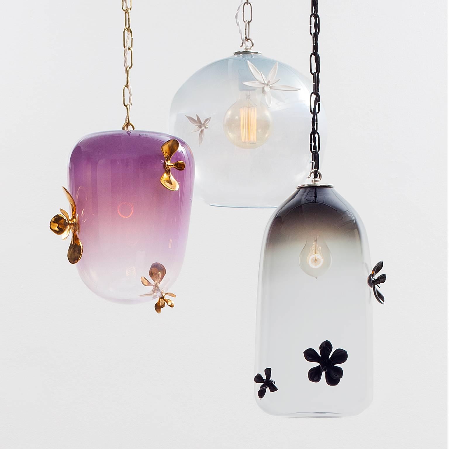 The Gia lighting collection consists of hand blown glass adorned with hand built porcelain plants. The glass pieces are offered in three forms: globe, lantern or bell.  The handcrafted porcelain ornaments are cast from live succulent plants. The
