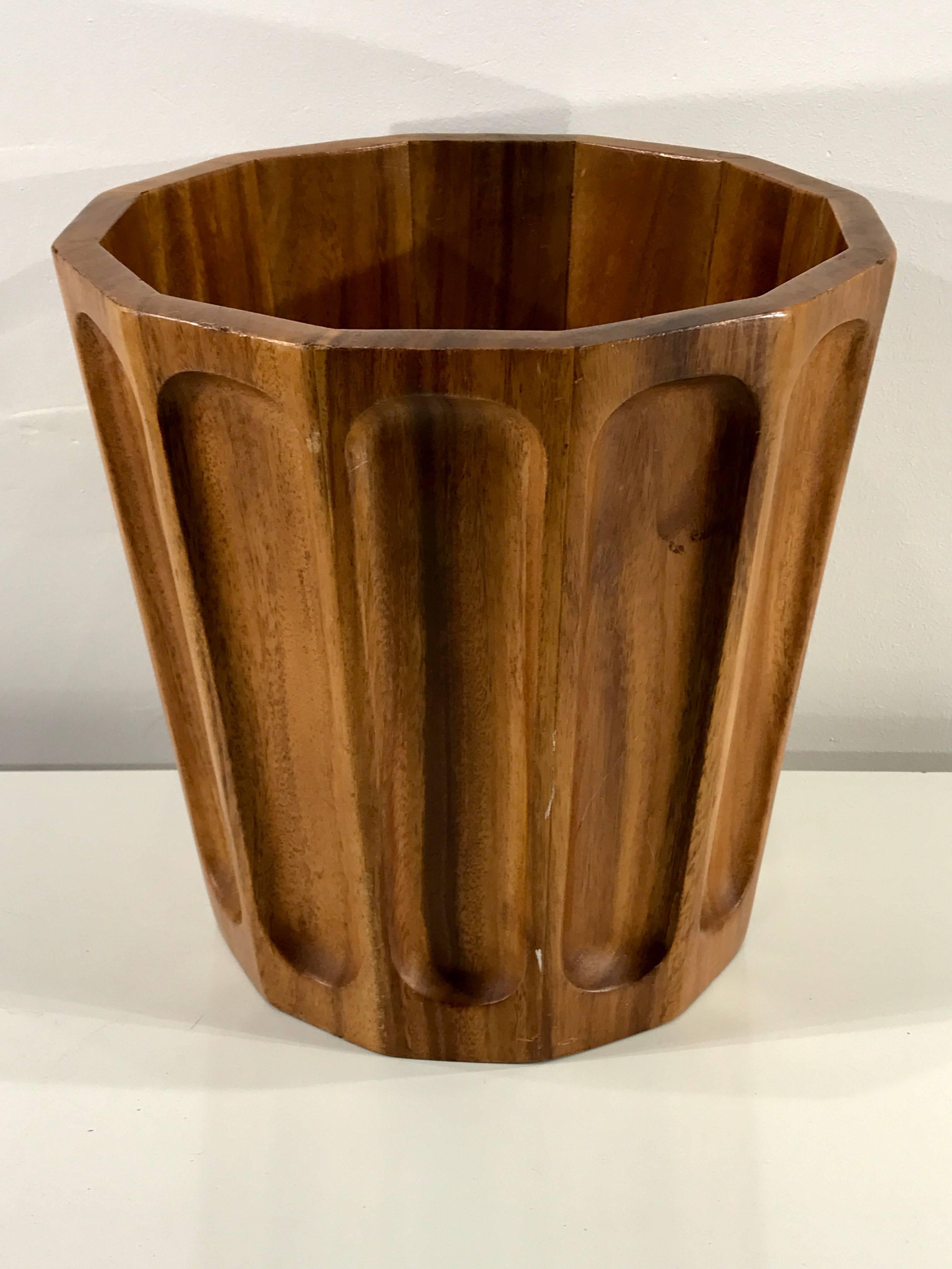 A period Danish modern sculpted teak trash can, measure: 12 inches high, 12 inches in diameter and 12 continuous fluted sides. Exquisitely crafted in untouched warm finished patinaed teak, with areas of varied reflective hues of copper tones. A