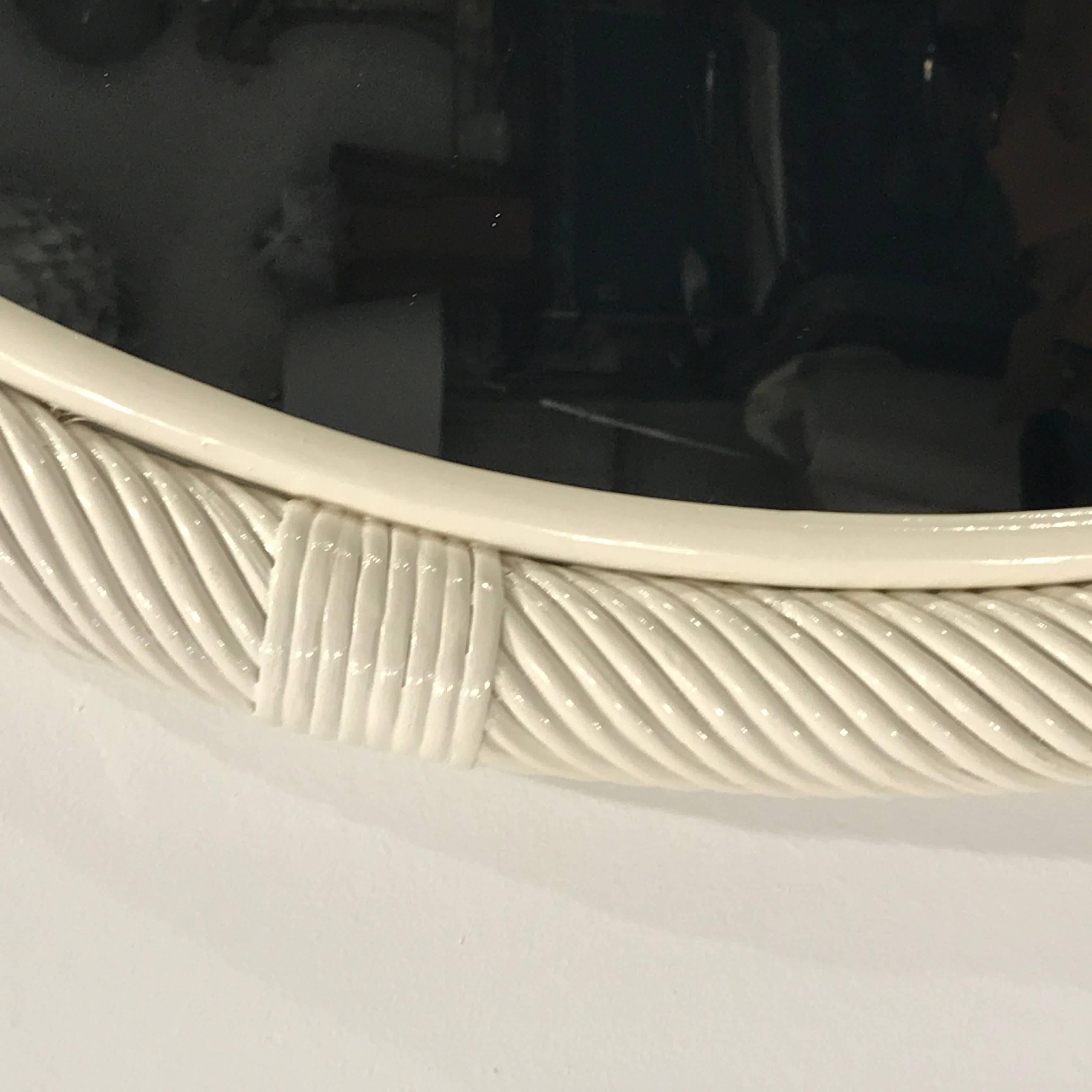 Large Chinese white lacquered circular rattan mirror, with continuous wrapped border with incremental woven rings, the internal mirror measures 28 inches in diameter.