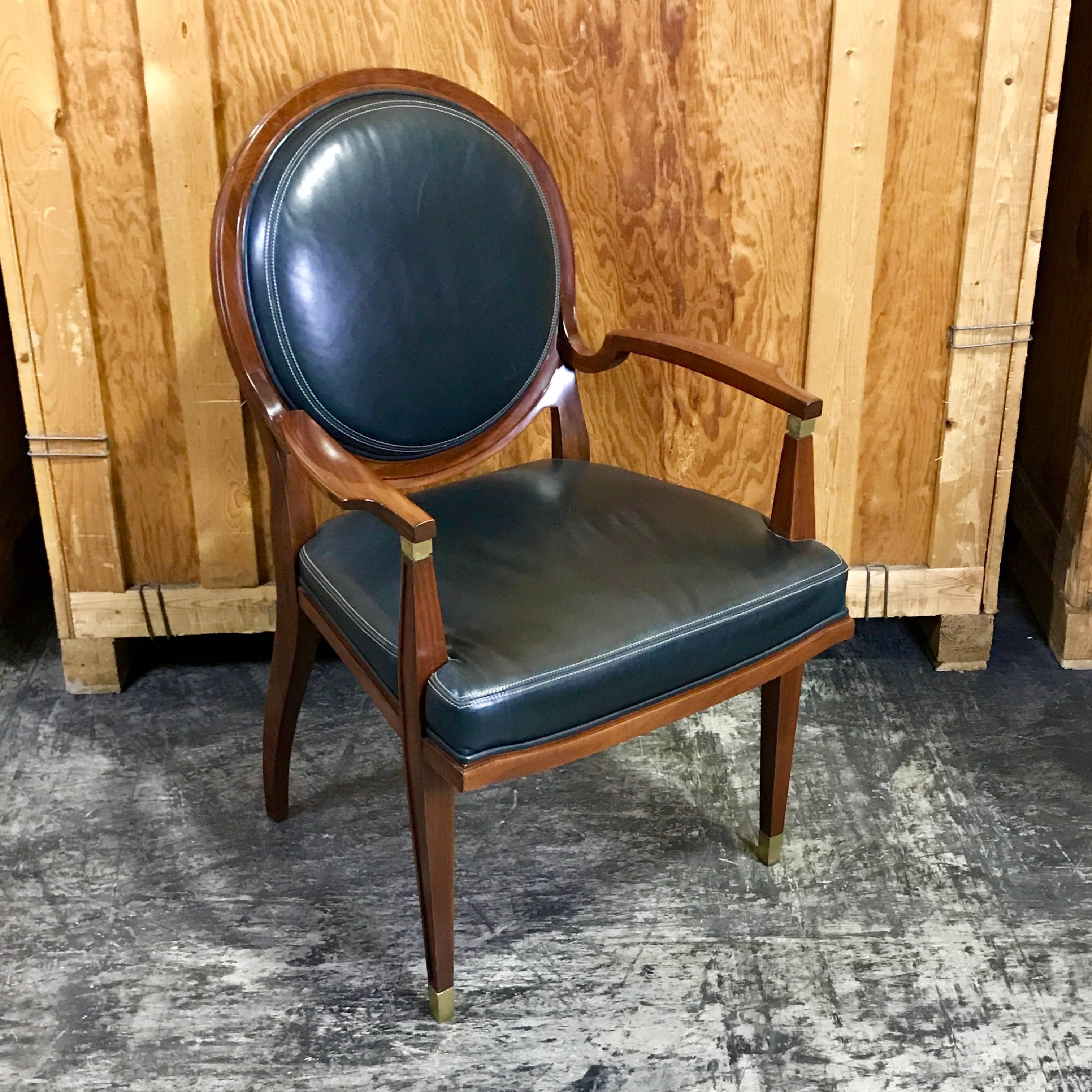 Beautiful leather armchair from the Lucien Rollin collection for William Switzer, with stitched black leather medallion backrest, brass-mounted carved arms. Conforming seat raised on brass sabot fitted front legs.