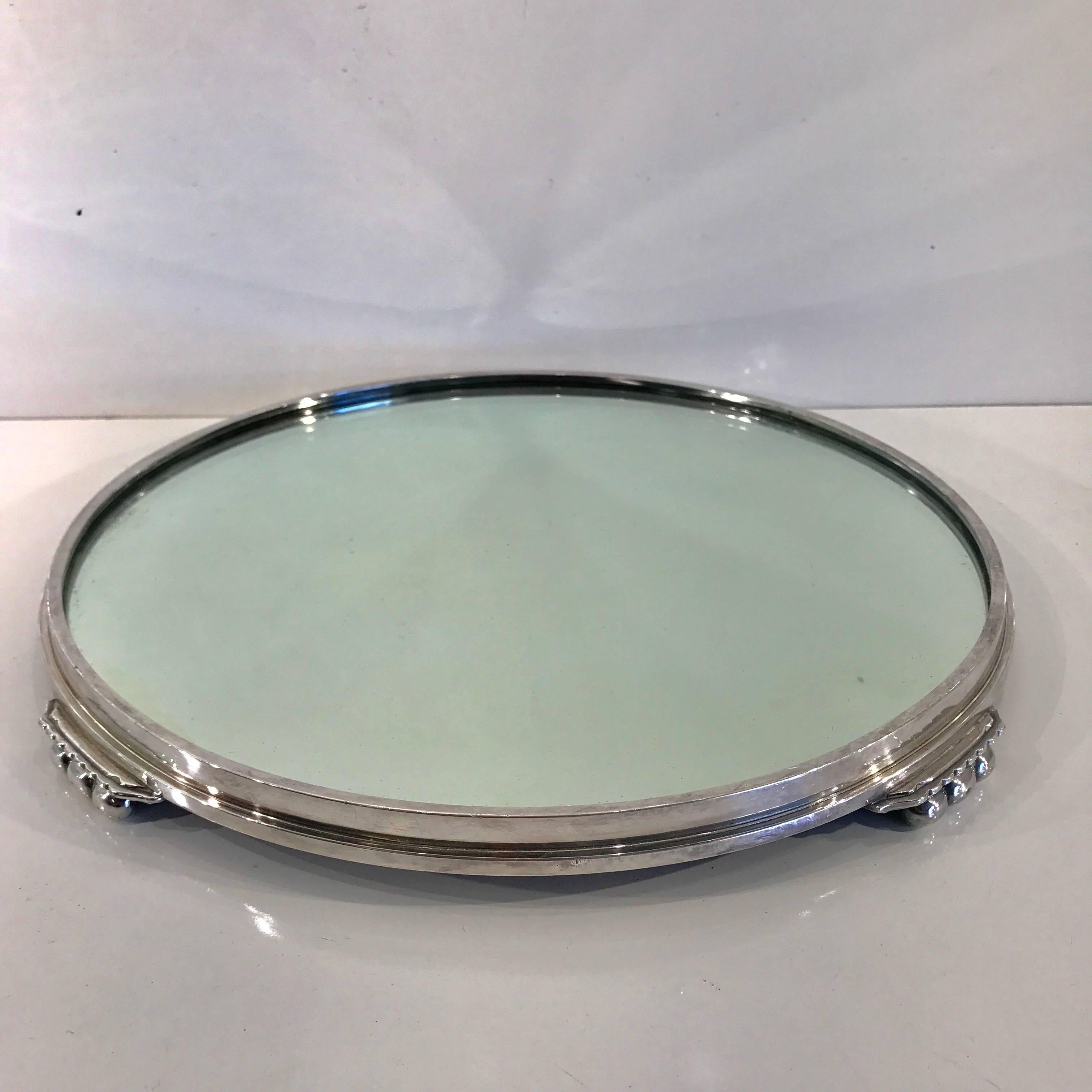 Art Deco silver plated round plateau, with inset 14" diameter original mirror, raised on four "Lug" feet, made by the International Silver Company.
This item is at our Atlanta GA, Location, not Palm Beach.
