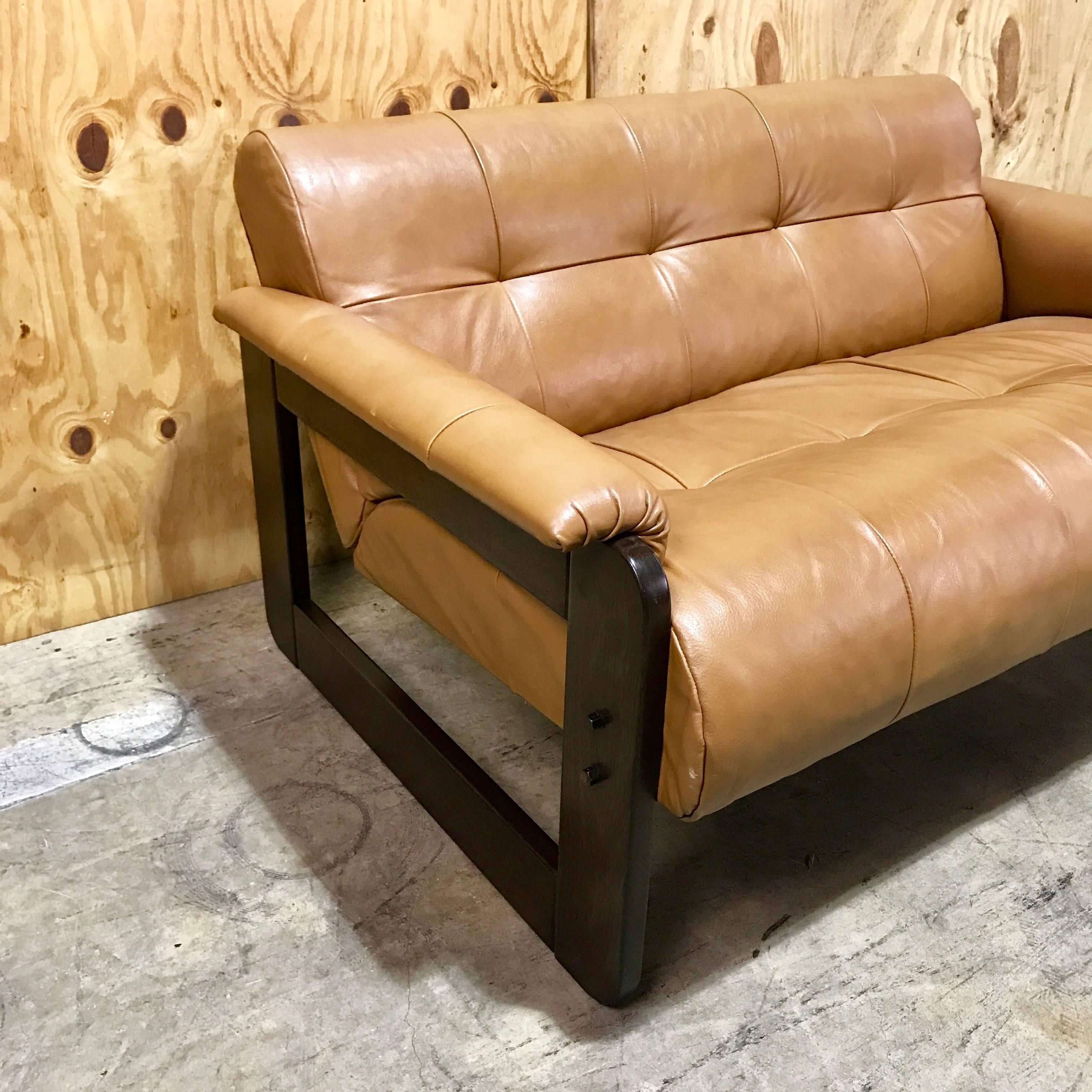 Brazilian rosewood and camel leather loveseat by Percival Lafer, clean lines with luxurious camel leather rolled arms, on rosewood cube frames. The back is finished in brown suede. Retains original paper label. The arm height is 19.5 inches