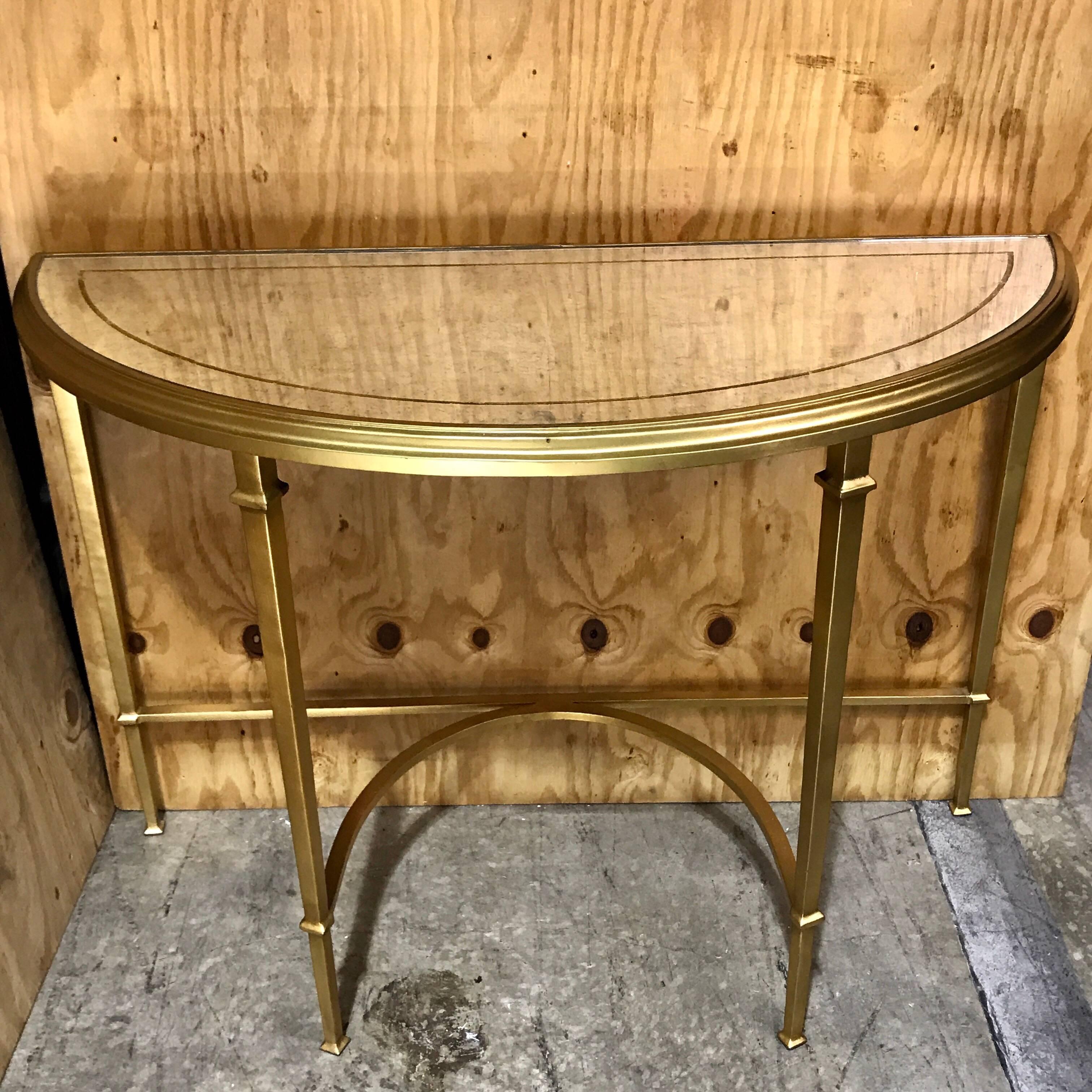 Modern gilt bronze and églomisé mirrored console table, exquisite casting and form, with half moon mirrored and gilt inset top raised on a conforming base with tapering column legs joined by a 