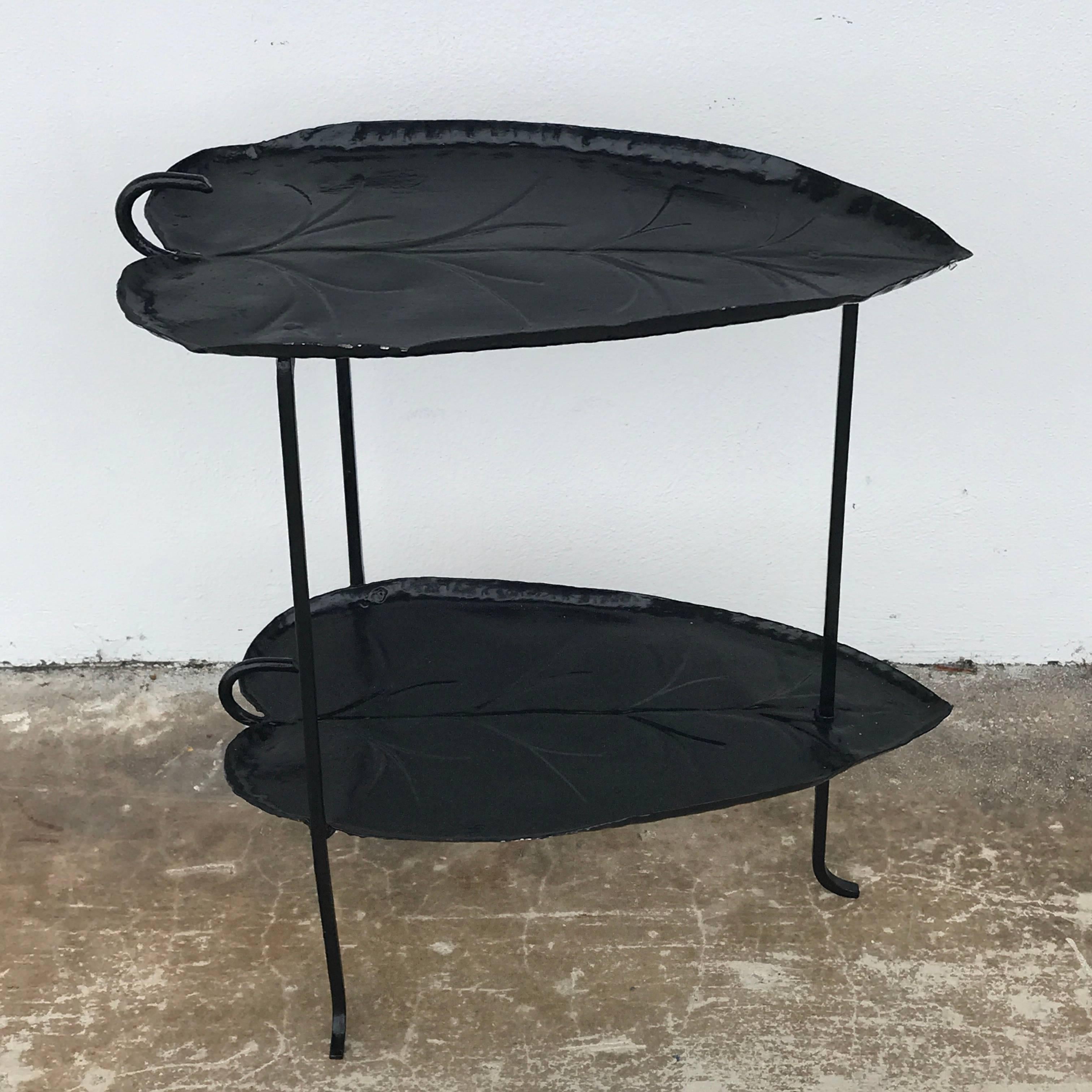 Rare Salterini two-tier leaf motif table, consisting of two 18" oval leafs raised on three sleek wrought iron legs, realistically cast and modeled. The height of the interior of the second shelf is 13.5" H.