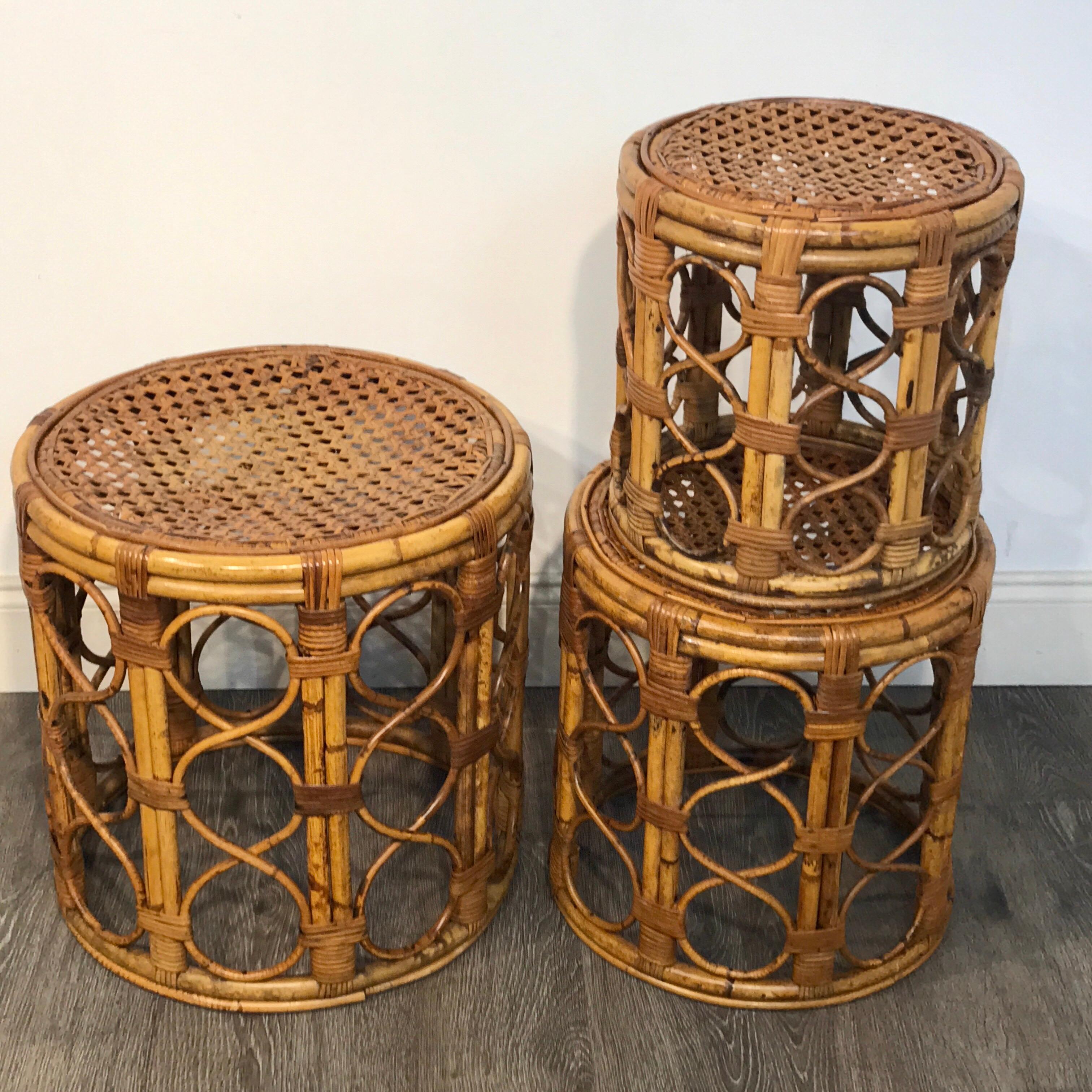 Set of three Graduating/ Nesting bamboo, rattan and reed nesting side tables, each one woven with interlocking circles and a caned top.
Measure: 13