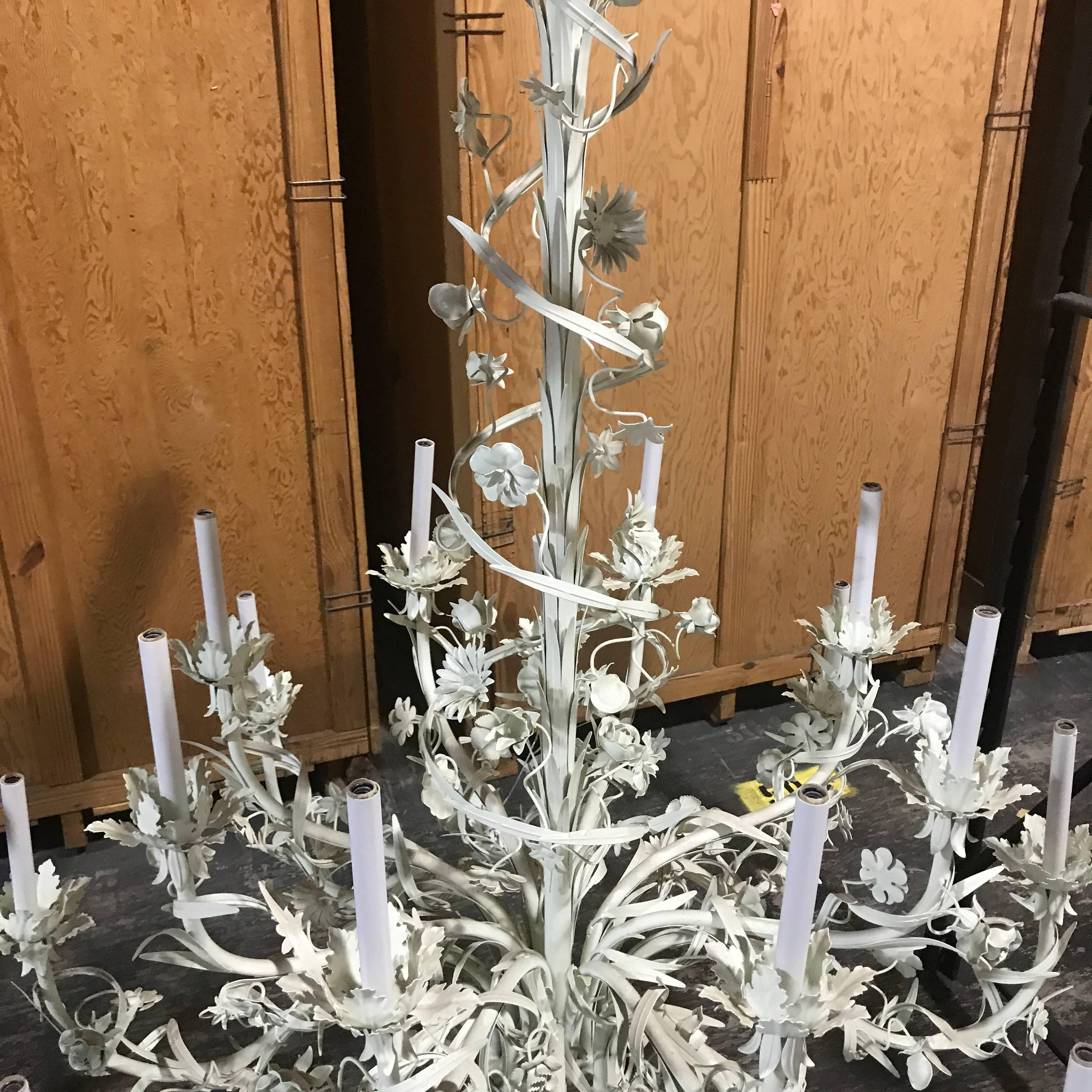 A large Italian 16-light two-tier white floral chandelier, abundance of cascading flowers and vines encircling two tapered levels of Eight ( 8 inches high) lights all in white enameled painted metal.
