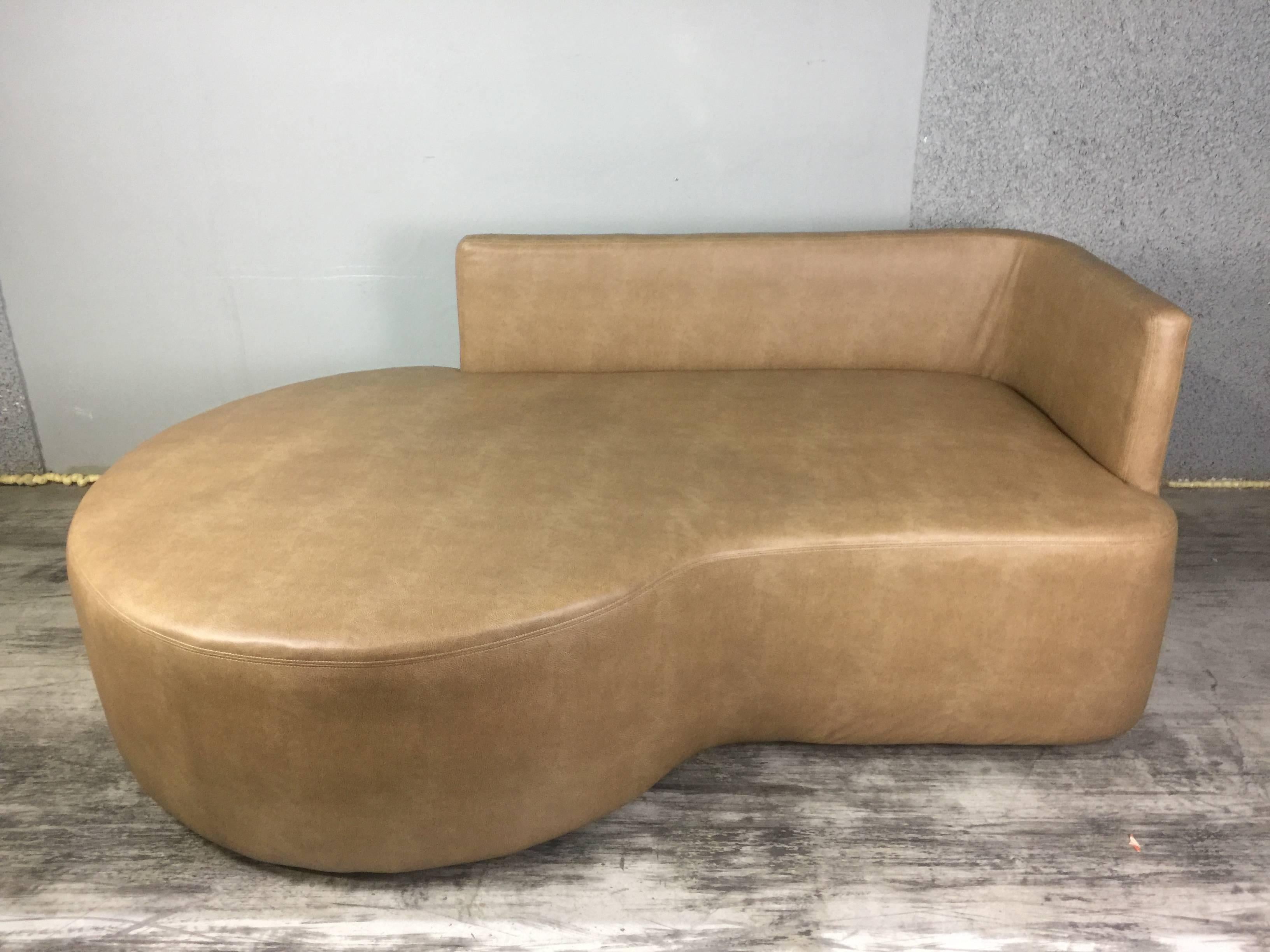 Kagan style saddle calfskin leather sofa, Sumptuous neutral saddle colored Calfskin leather upholstered asymmetrical sofa. The sofa measures 79" H x 31" H and has a varying depth from 33"-45.5" deep. The 3/4 backrest measures