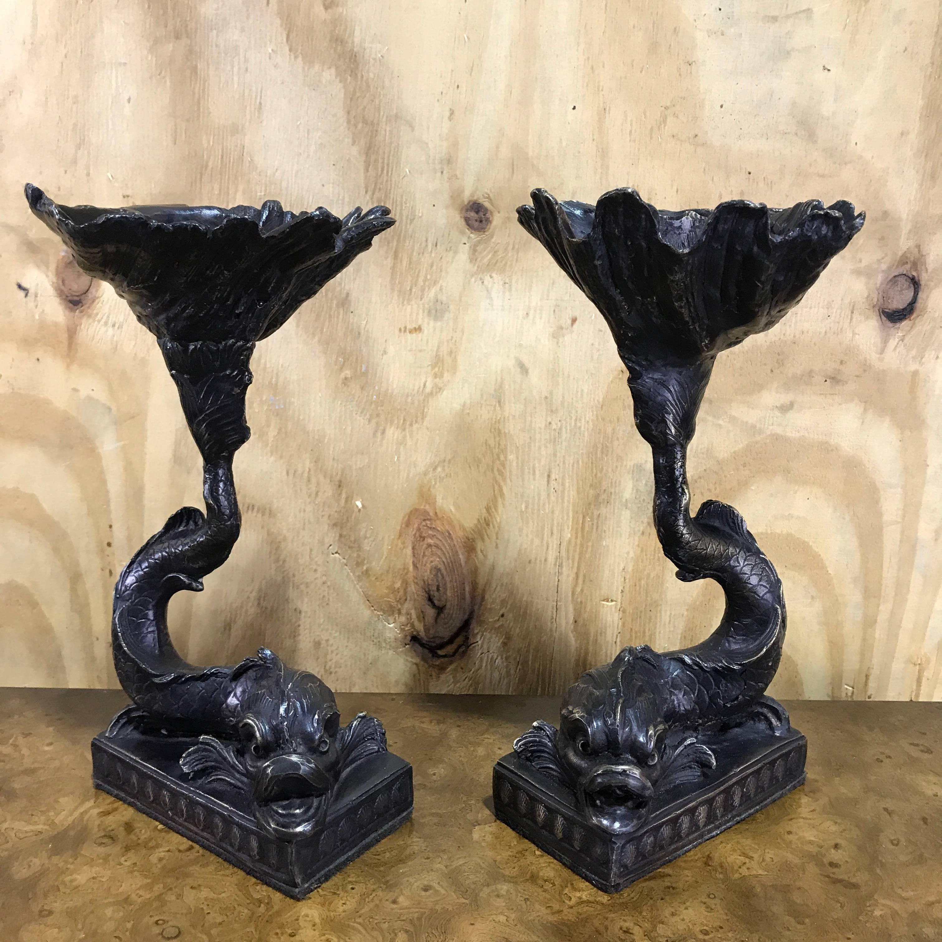 Pair of Italian bronze dolphin and shell motif tazza, each one realistically cast with tails supporting a clam shell tazza.
The base measurers 3.5