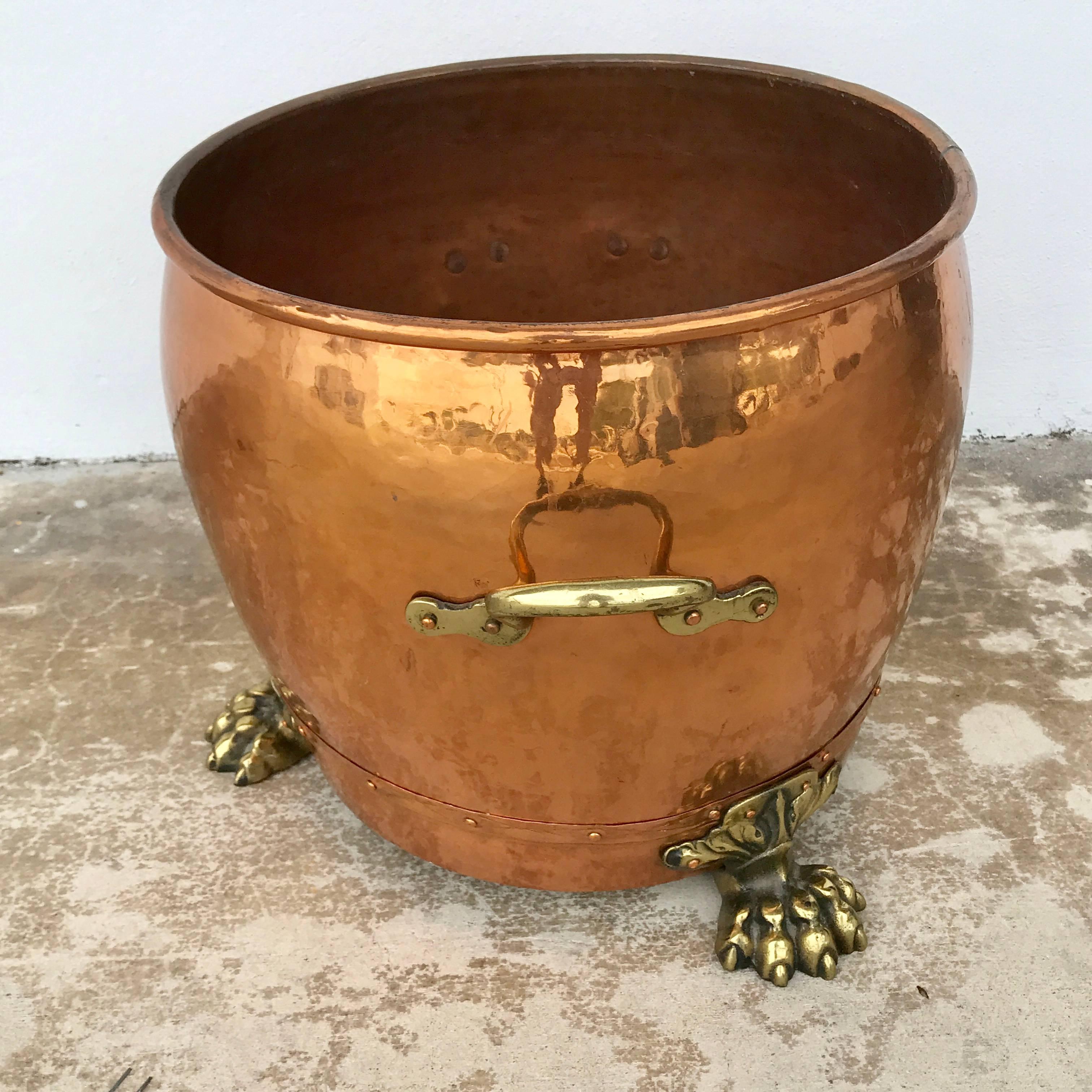 English copper and brass planter, of circular form with two brass handles dovetailed construction, raised on three brass paw feet, stamped 