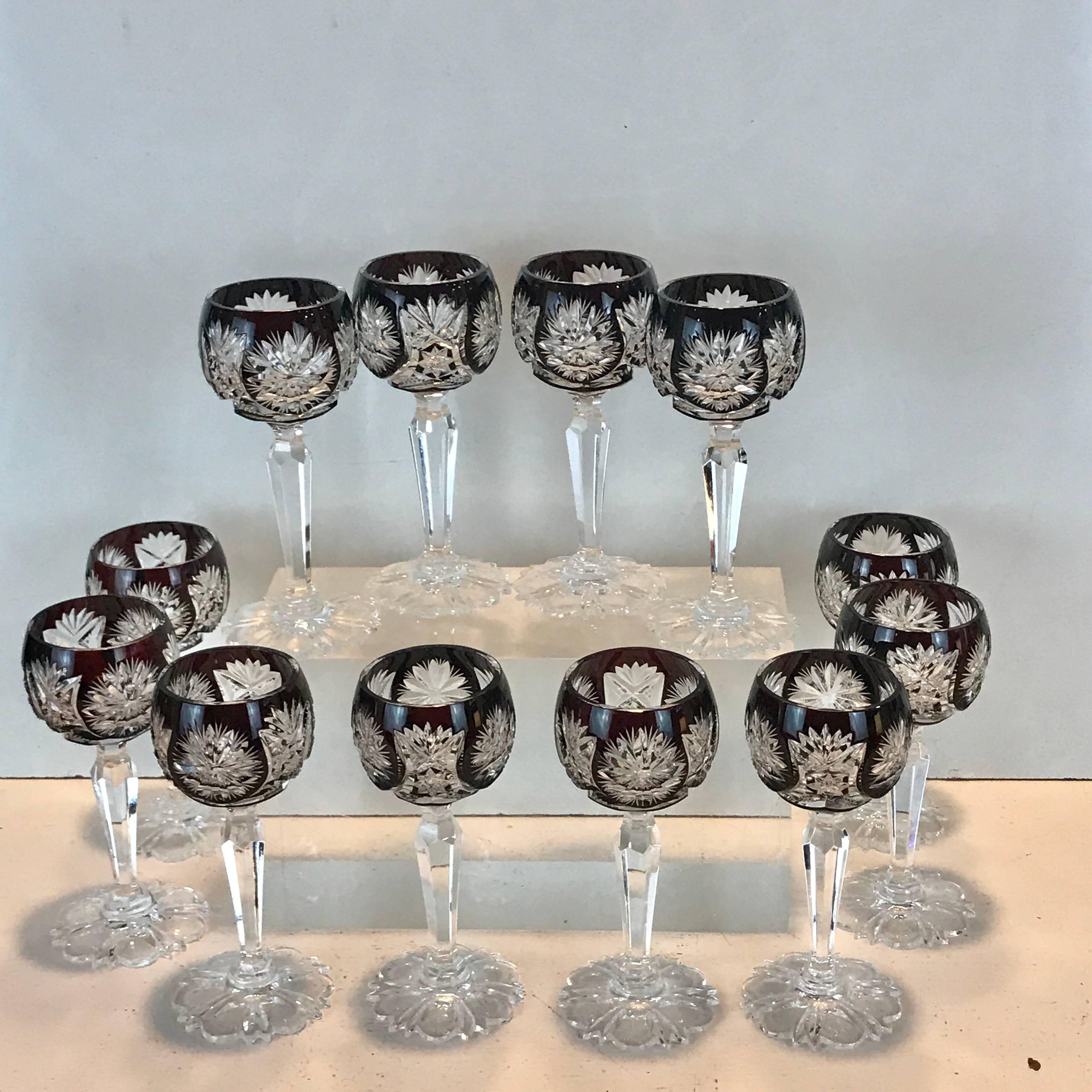 Set of 12 ruby red cut to clear cordials, attributed to St. Louis, Each one with snowflake cut glass panels, with intricate cut six stem petal motif foot (base)
Unsigned
Each glass stands 4.5