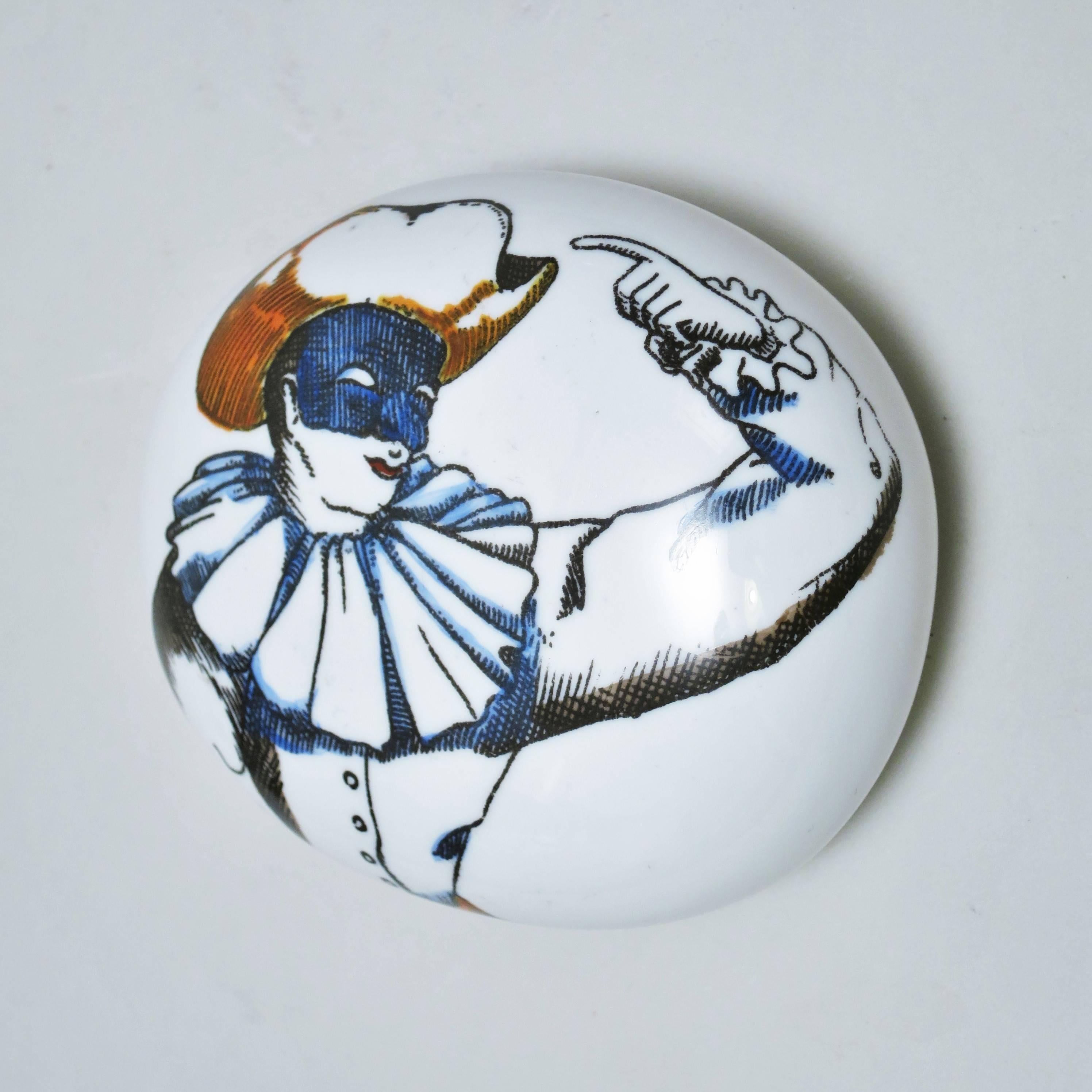 Porcelain pebble paperweight with a decor of a character from the Commedia dell'arte: Pulcinella (Punchinello) by Piero Fornasetti, circa 1950. Signature under the base.