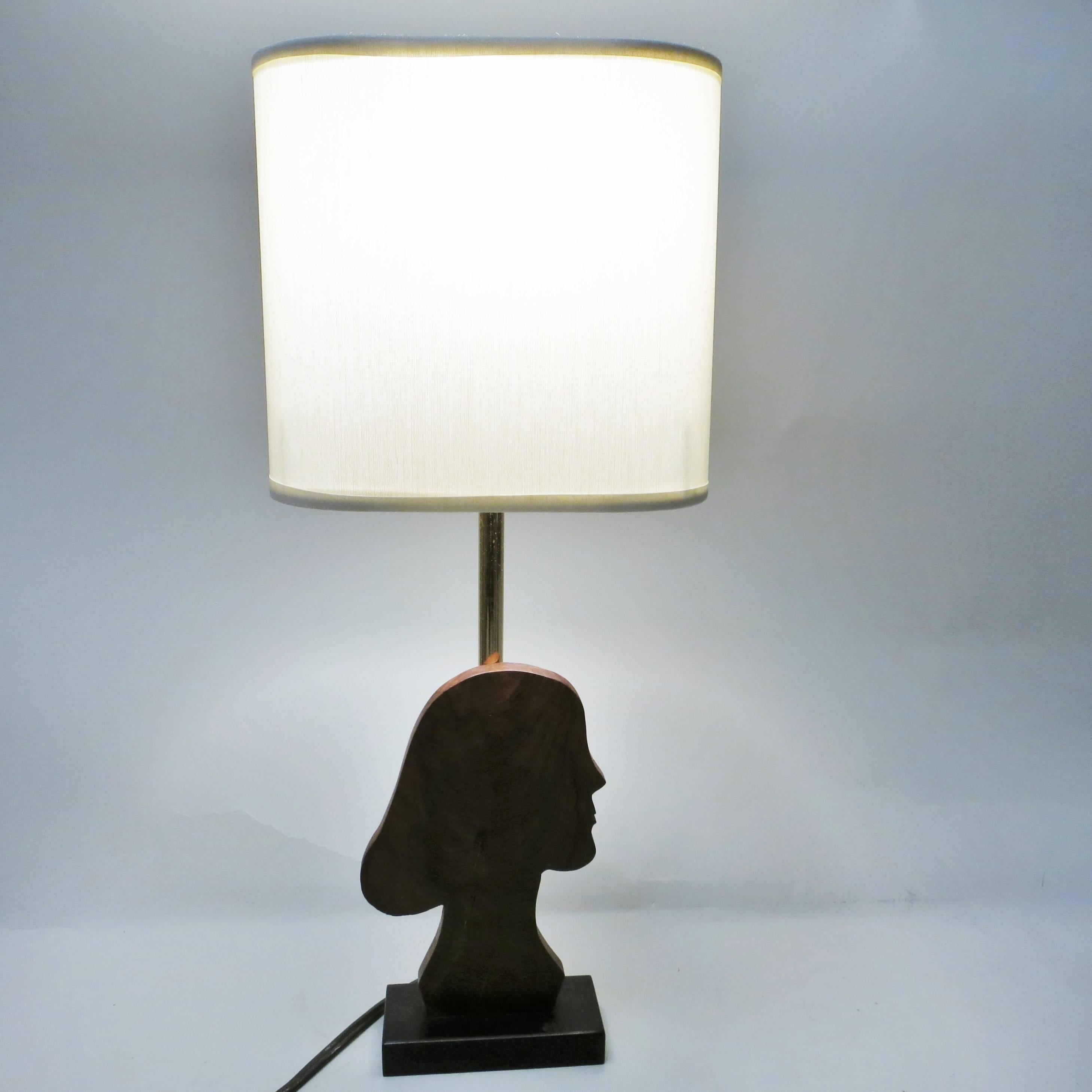 French Mid-Century Modern lamp with a Silhouette of a girl face in elm on a ebony base. The base is signed with a unknown monogram HS. The fabric shade is on a gilded metal rod. The shade is not original.