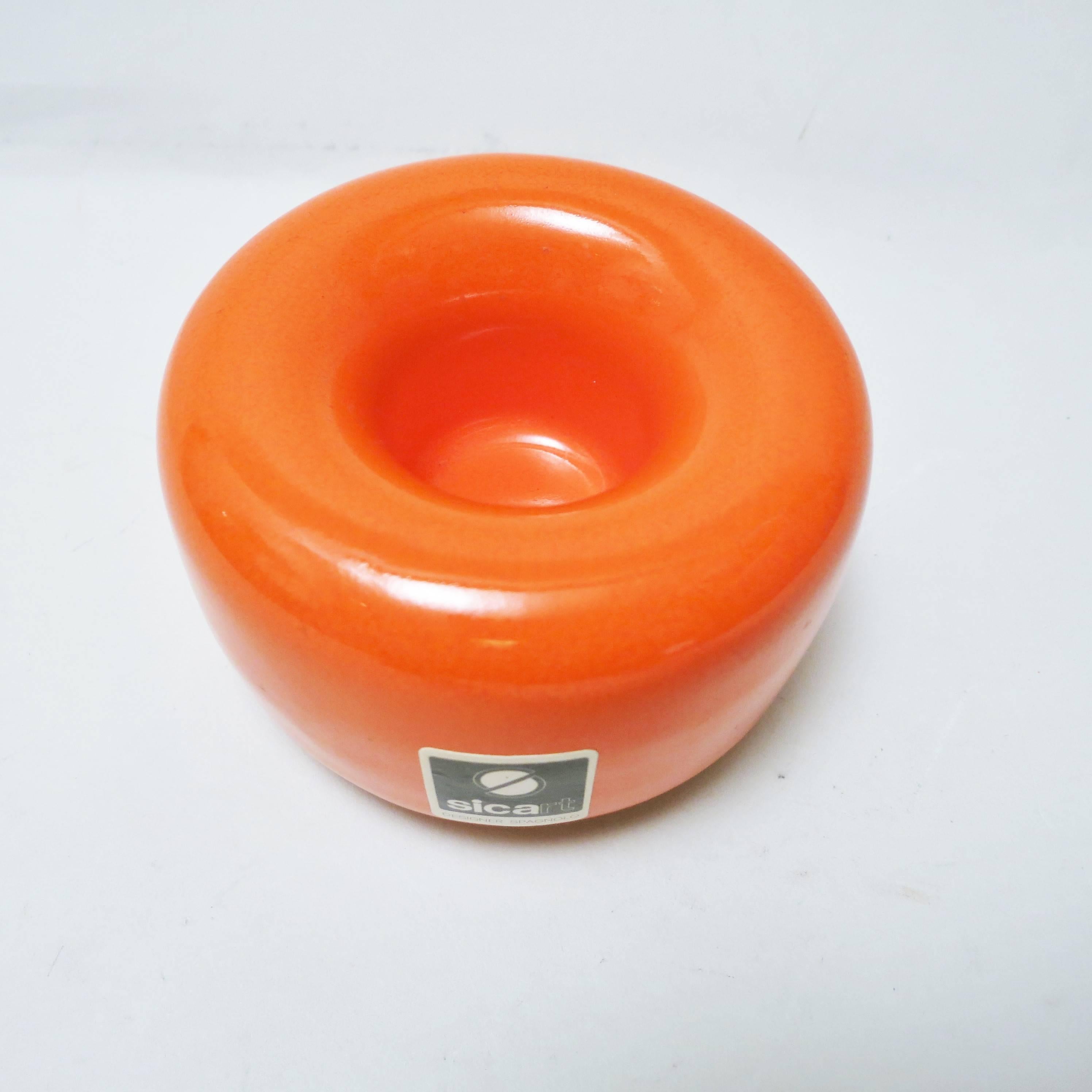 Circular and curved ashtray in orange enamelled ceramic designed by Pino Spagnolo for Sicart in the early 1970s. Labelled on the edge, stamped under the base.