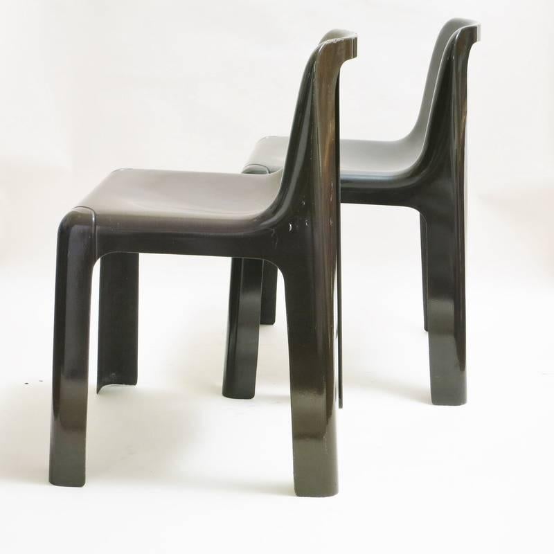 Pair of French iconic dining chairs Ozoo designed by Marc Berthier in 1970 for Roche Bobois made of fiberglass lacquered brown. Stackable. One little lack of lacquer on the back on one chair.