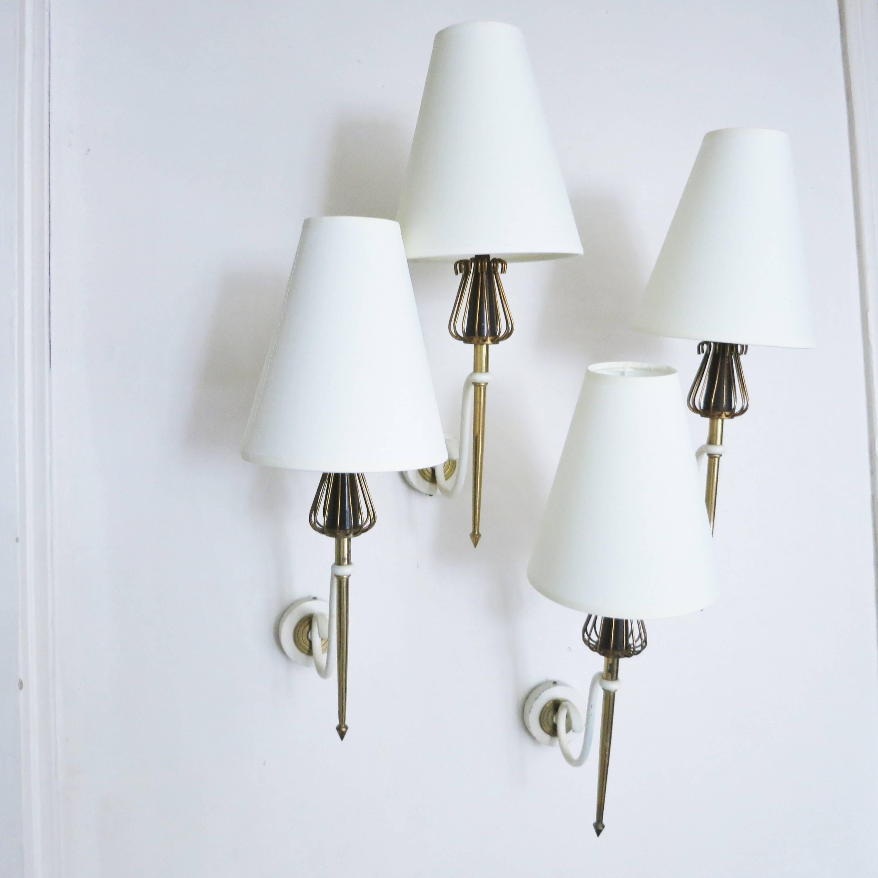 Set of four French Mid-Century Modern sconces by Maison Lunel in brass, brown bakelite, white lacquered metal, and fabric shades,
circa 1950.