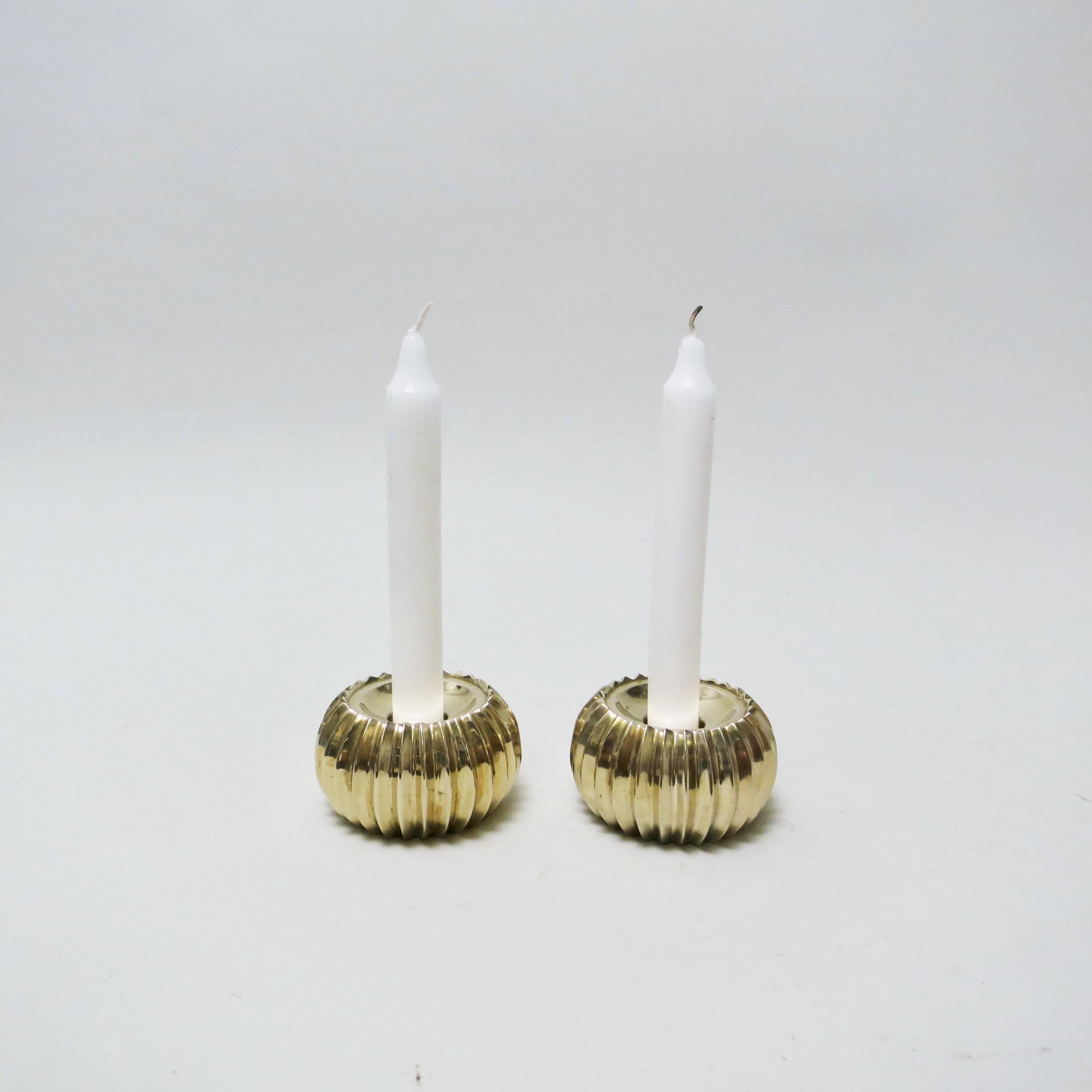 Pair of scandinavian candleholder from the 1960s. Beautifull round form with fluted decor made of molded brass for a single candle of 1cm diameter. 
Beautiful original condition.