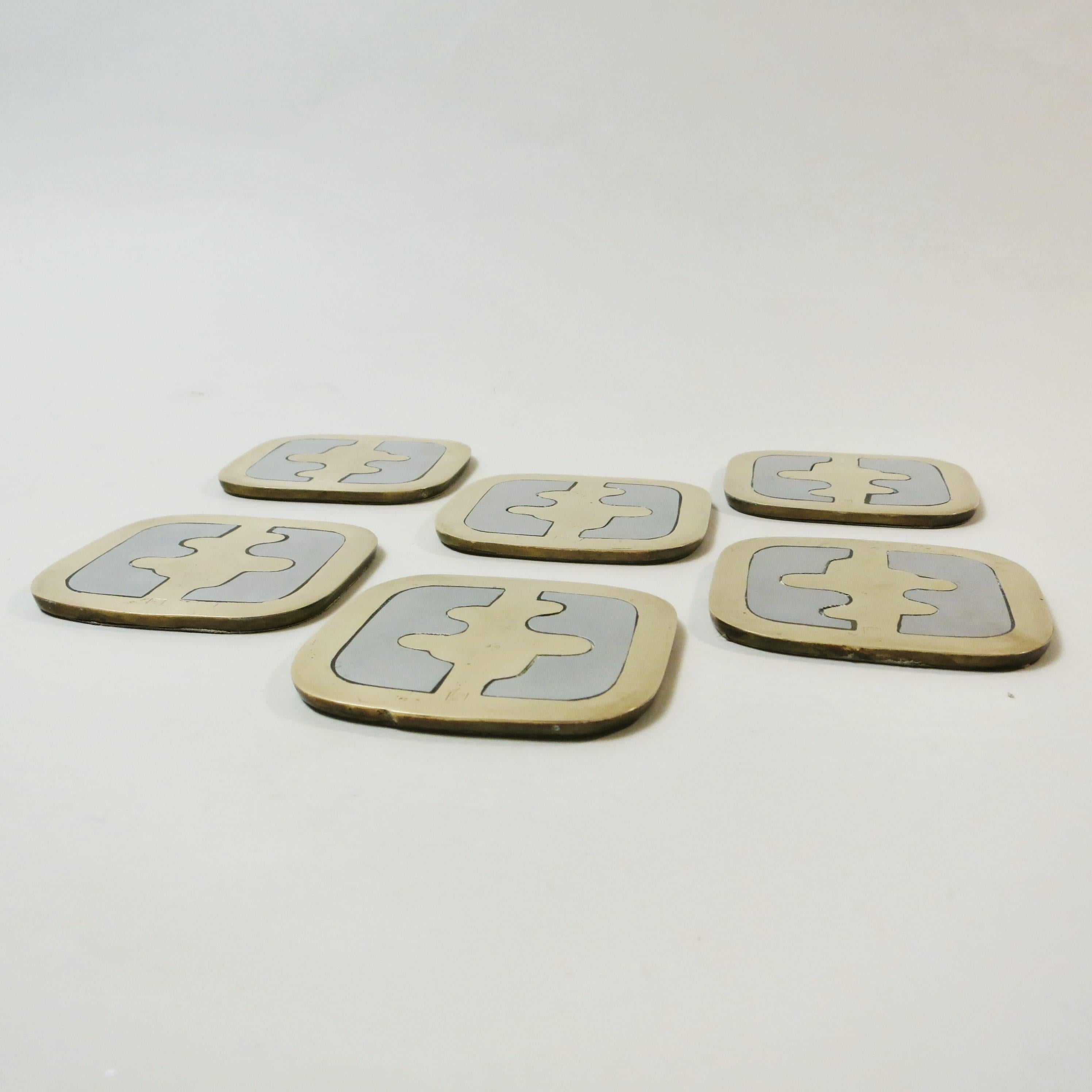 Set of six Brutalist coaster in brass and aluminium cast made by David Marshall in Sevilla Spain, circa 1970. All coaster are handcrafted and are a little bit different from each other. Labelled on the back on a leather cover.