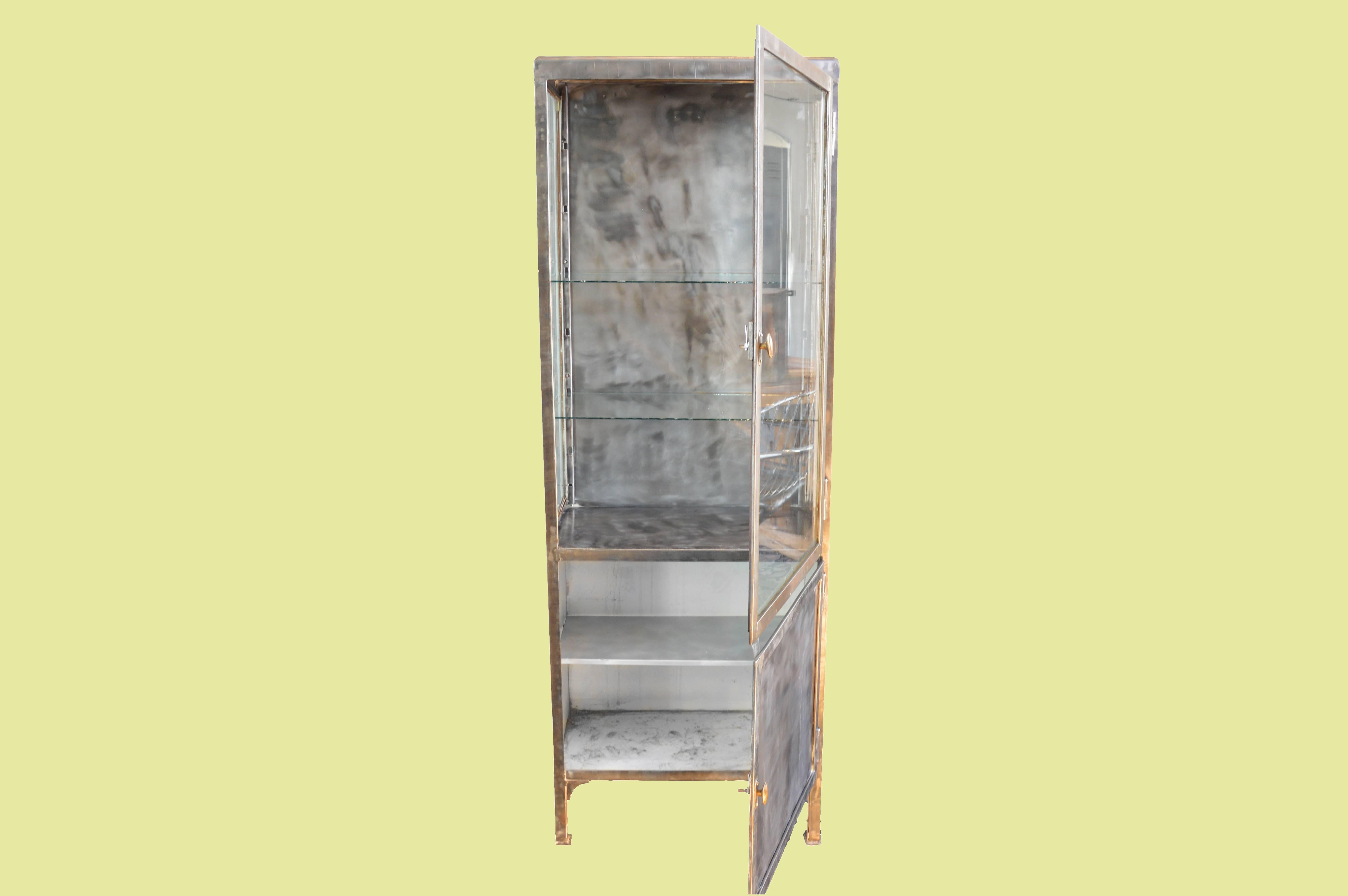 This vintage 1950s Industrial pharmacy cabinet origins from Eastern Europe and was used in hospitals and pharmacies. 

The cabinets were originally painted white, but we used special techniques, burned the paint of, polished the steel and made