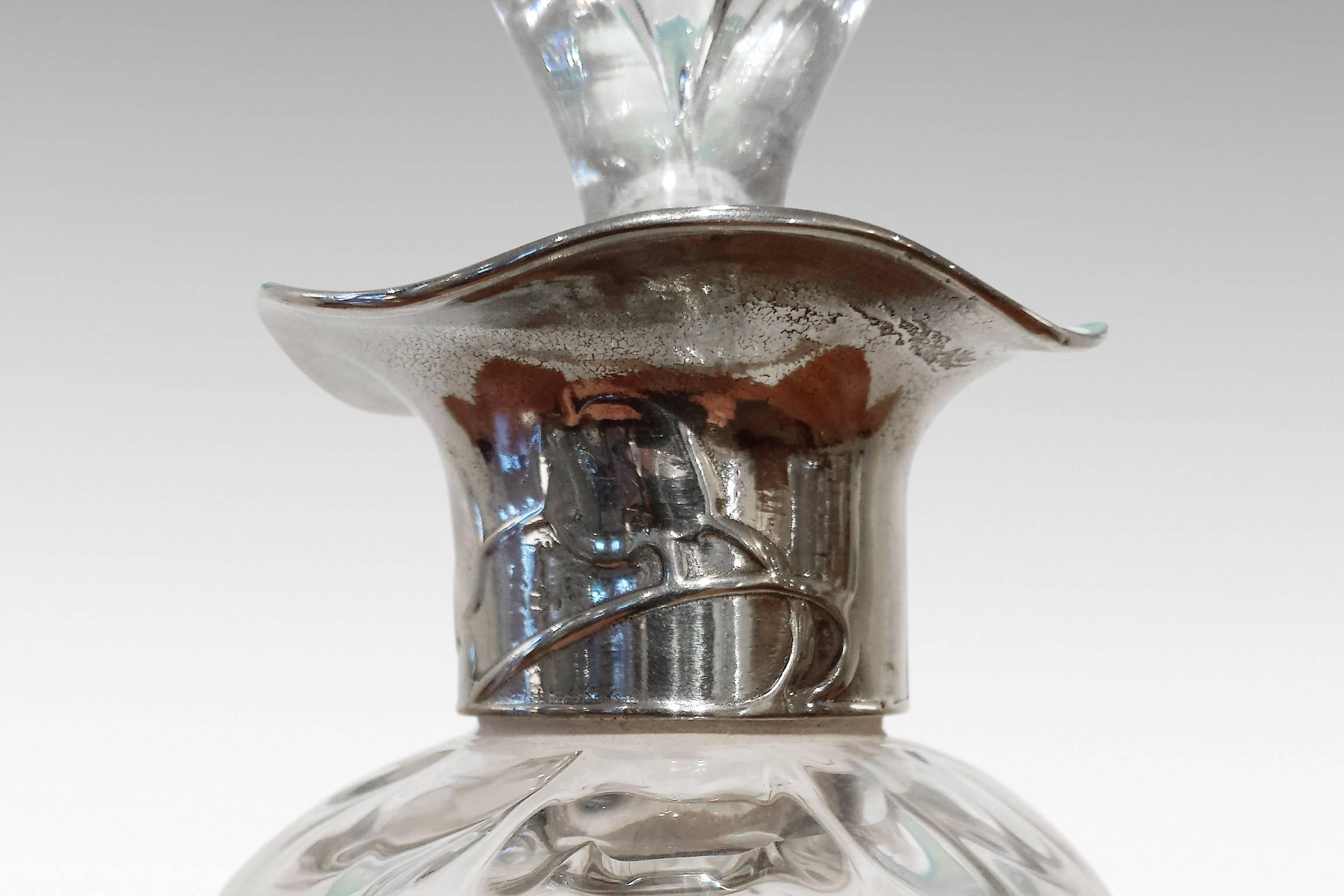 A decanter with Pewter collar incorporating Honesty decoration, designed by Archibald Knox and retailed by Liberty & Co. The glass by James Powell and Sons of Whitefriars.
Literature: Stephen A Martin, 'Archibald Knox' (London, Artmedia: 2001), p