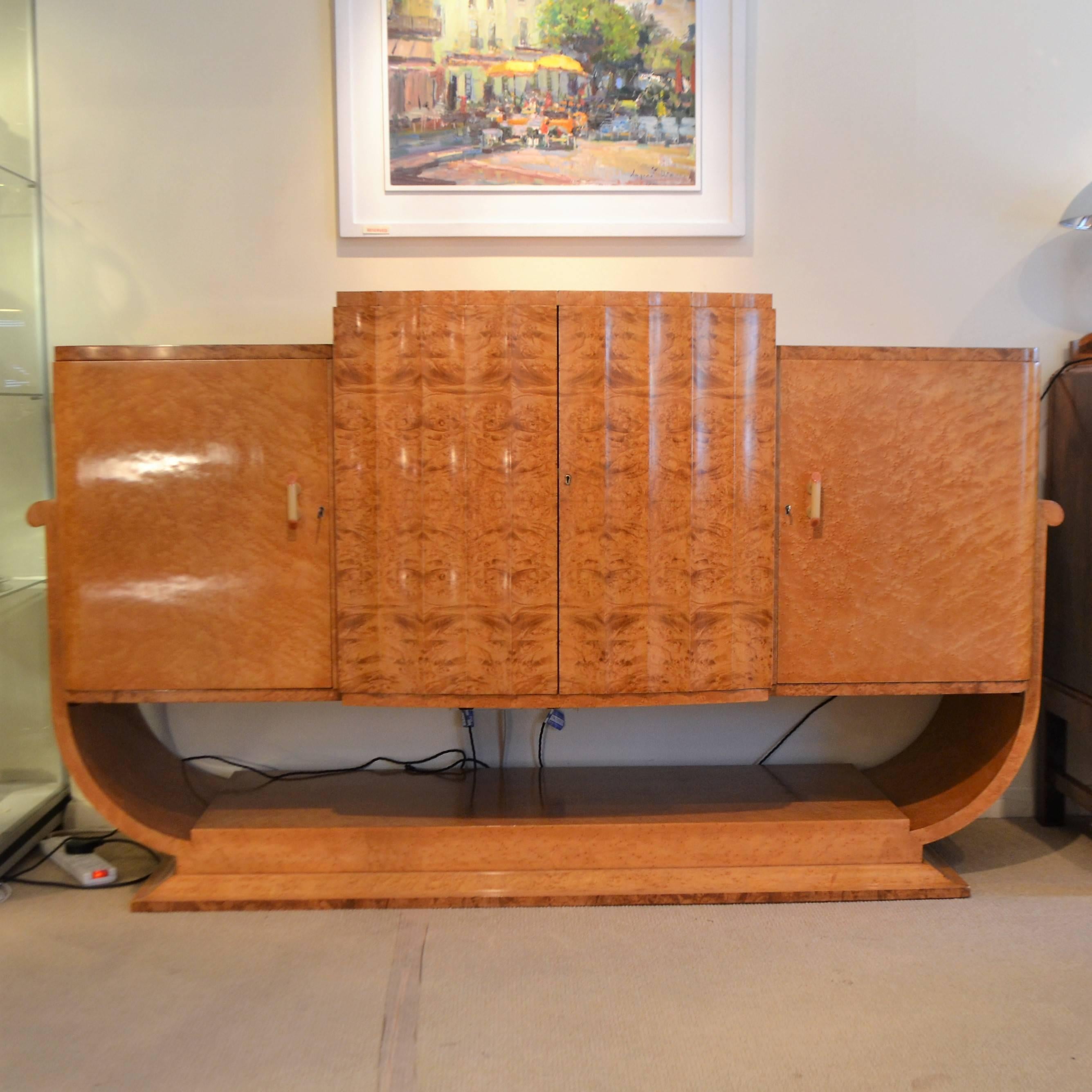An original Classic U-base sideboard by Epstein in bird's-eye maple veneers. The centre doors enclosing three drawers, each constructed using handmade dovetail joints and with Bakelite handles.
circa 1930s-1950s

(This sideboard is en-suite with