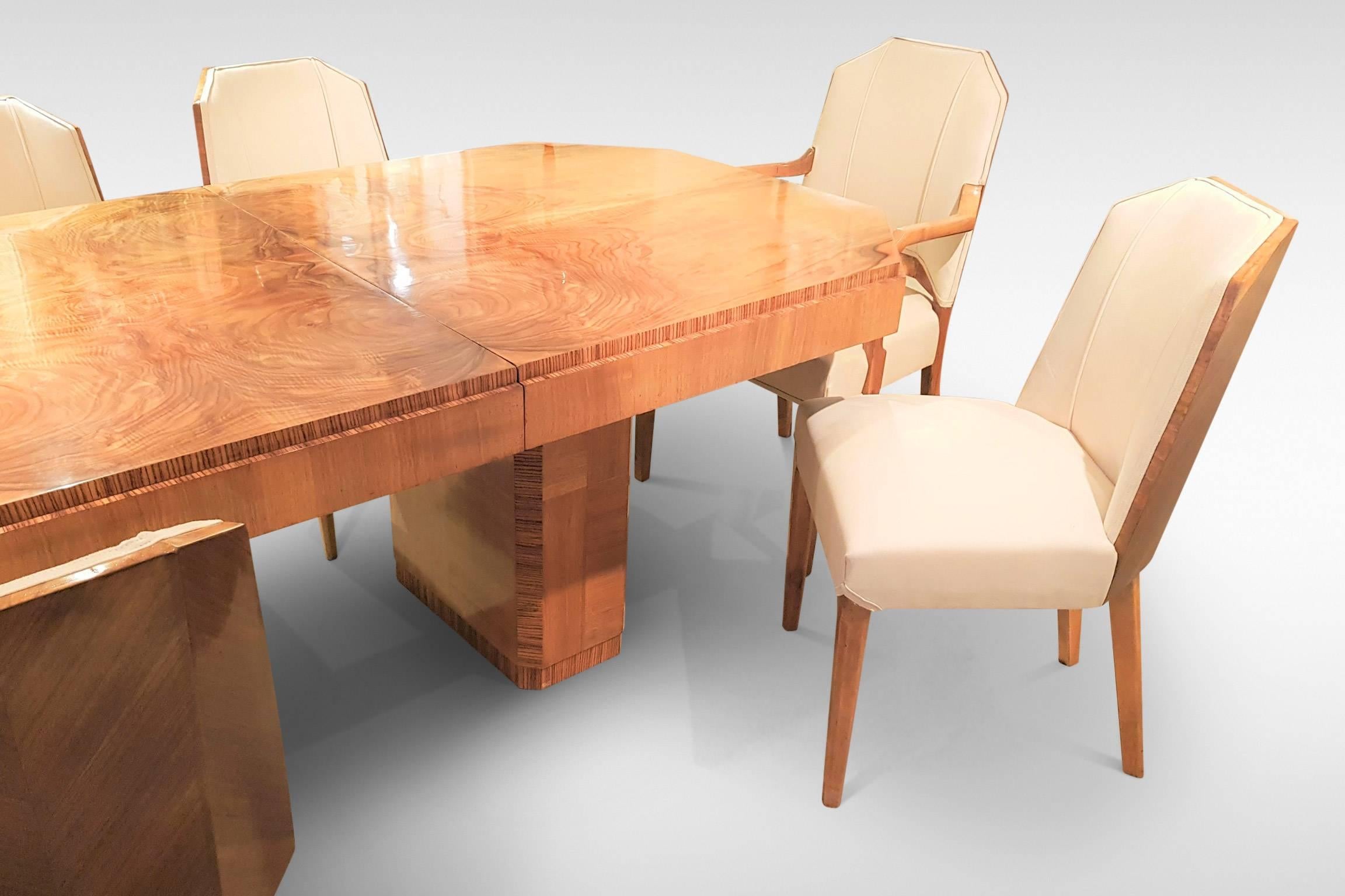 This is a stunning example of fine quality British geometric Art Deco furniture. Attributed to Hille, the matched set comprises a rare extending eight-seat pedestal dining table with six geometric dining chairs and two carver armchairs in a related