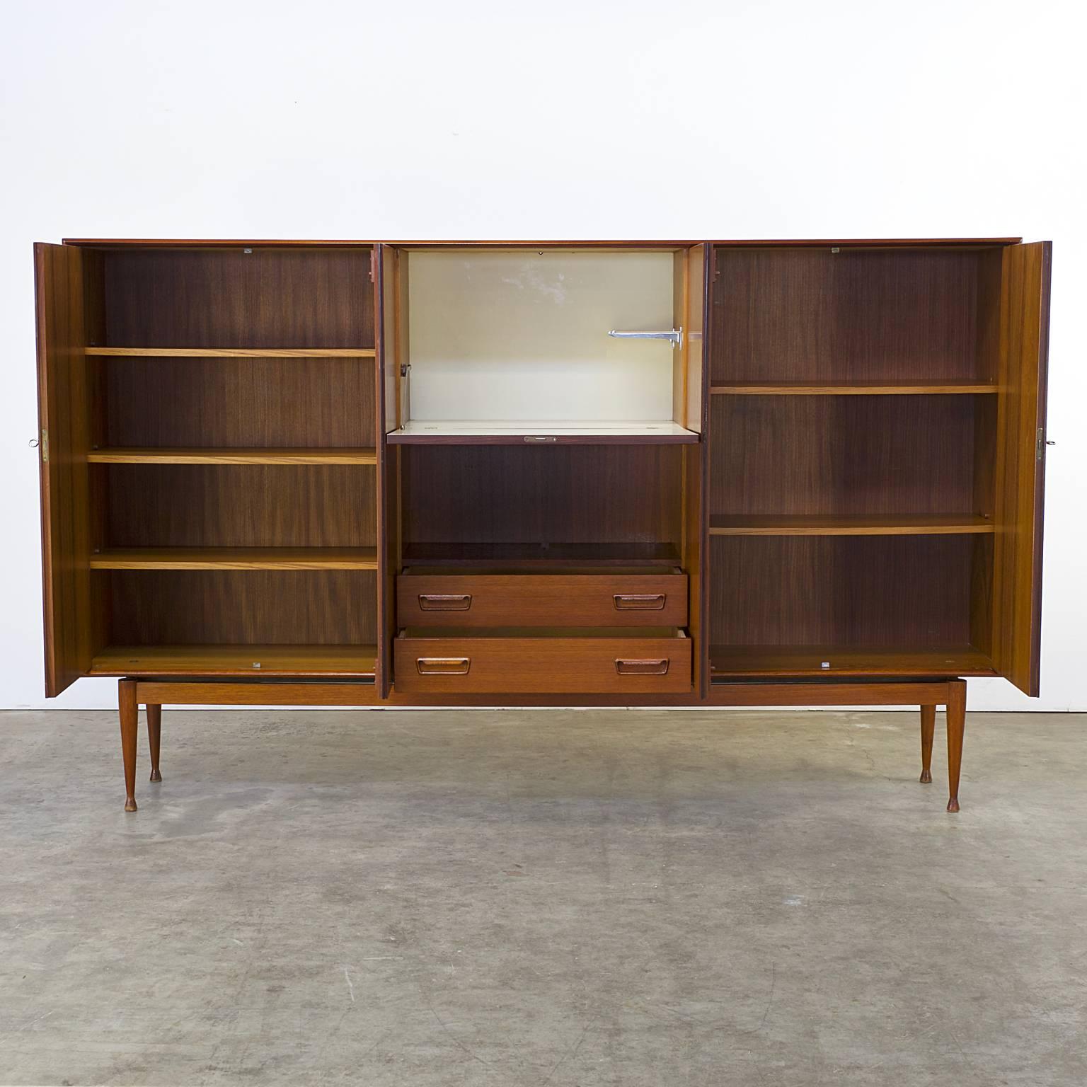 1960s teak cabinet four doors, two drawers, one flapdoor attributed Arne Wahl Iversen for Vinde Mobelfabrik, Denmark. Teak, good condition, wear consistent with age and use, minimal scuffs on one side of the top. Dimensions: 220cm W x 39cm D x 135cm