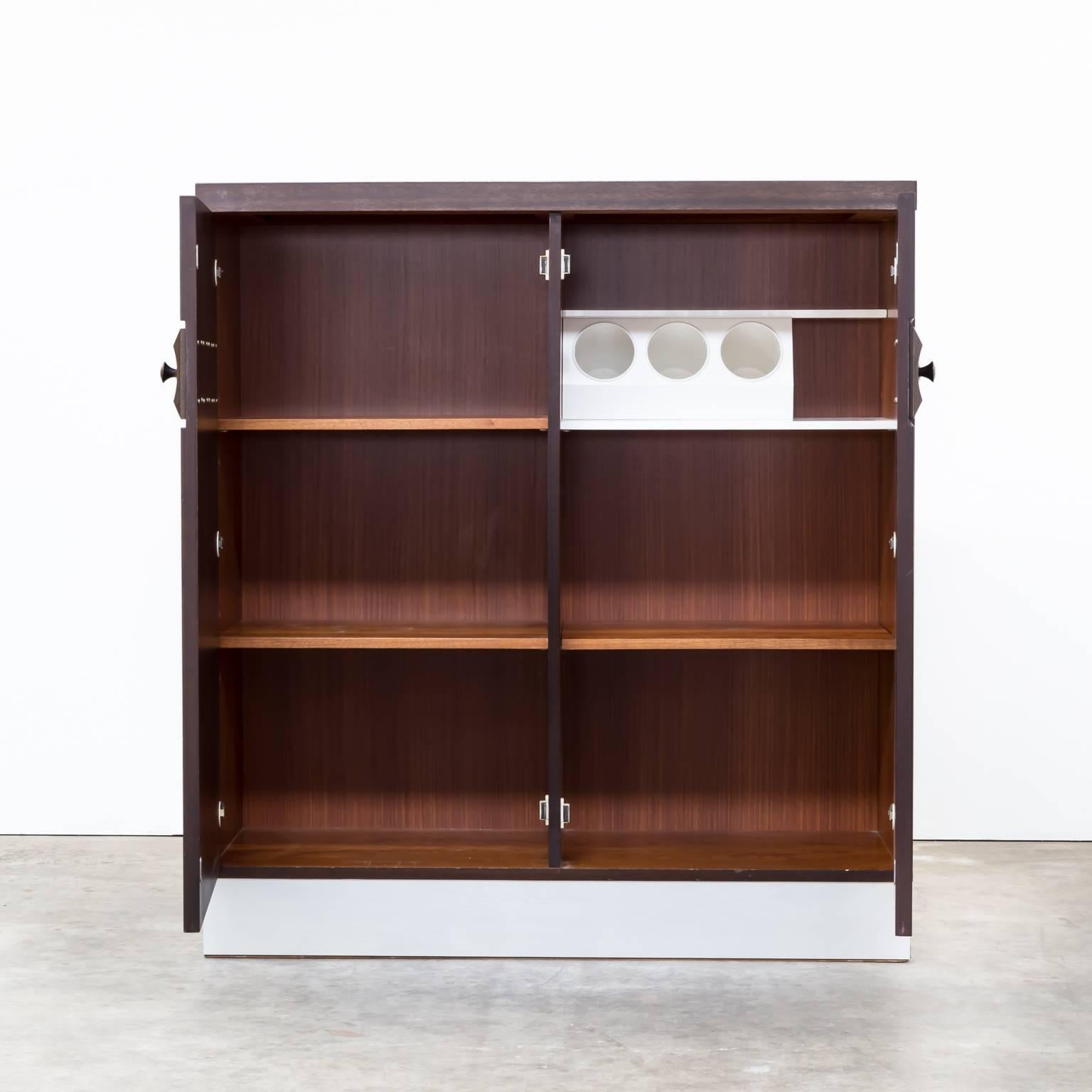 1970s Belgian Brutalist credenza high sideboard attributed “De Coene” in red or brown teak. Silver plint. Original condition, wear consistent with age and use. Dimensions: 110cm W x 44,5cm D x 120cm H.