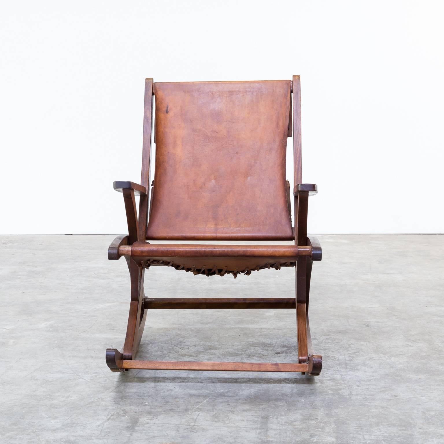 Mid-Century oak and saddle leather rocking chair. Beautiful frame and cognac colored saddle leather. Dimensions: 60cm W x 92cm D x 88.5cm H, seat H 33cm.