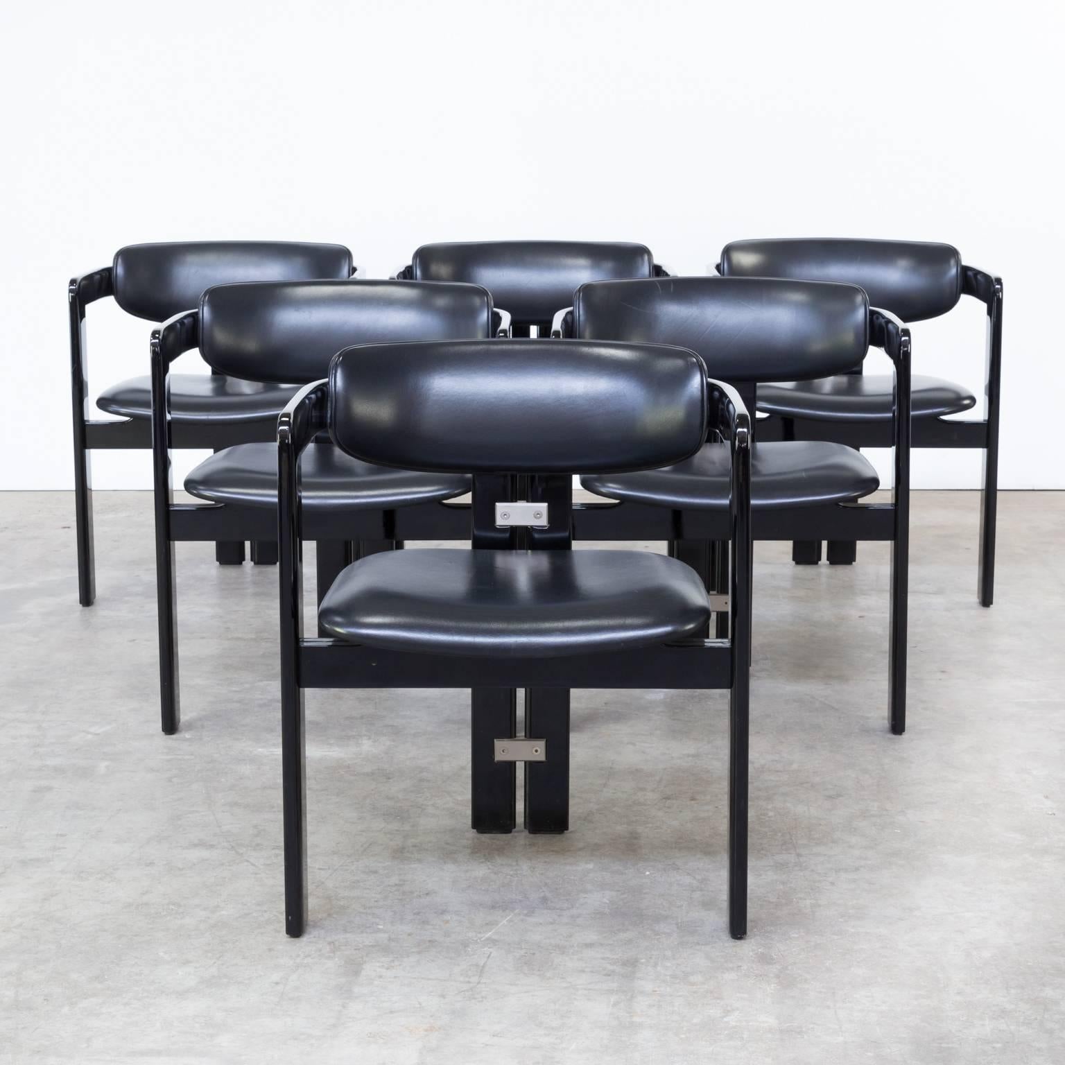 One set of six chairs. This chair was designed by Augusto Savini from the 1960s and manufactured by Pozzi, in Italy. It is covered in its original black leatherette and it features a black piano lacquered frame and aluminium metal connections. The