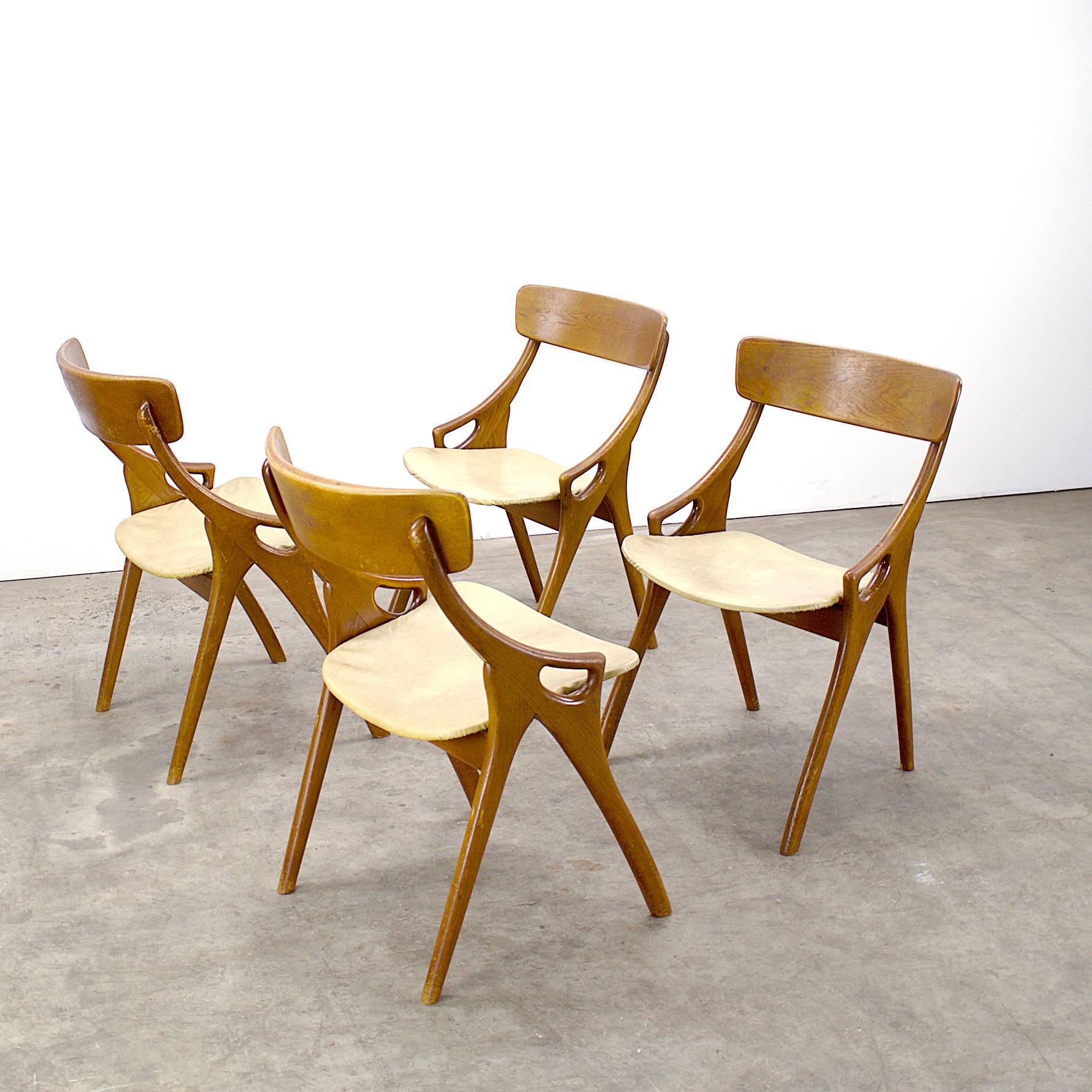 One set of four Arne Hovmand Olsen dining chairs for Mogens Kold Furniture. Wooden frame, and plywood seat decorated with skai seating. The skai might need attention, is in vintage condition. The chairs and wood are in very good condition. Seat