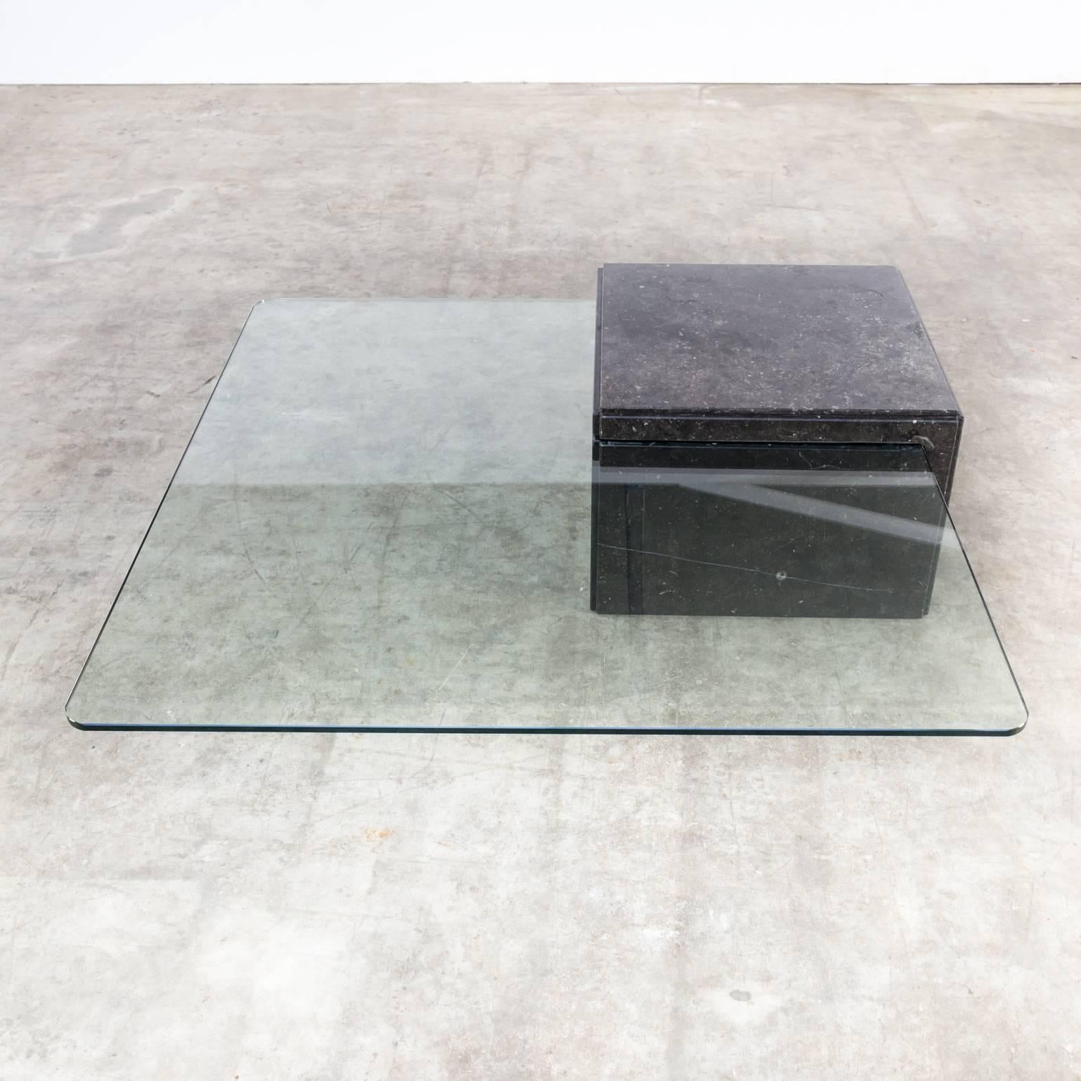 A glass and granite coffee table from the 1970s in good condition, wear consistent with age and use.