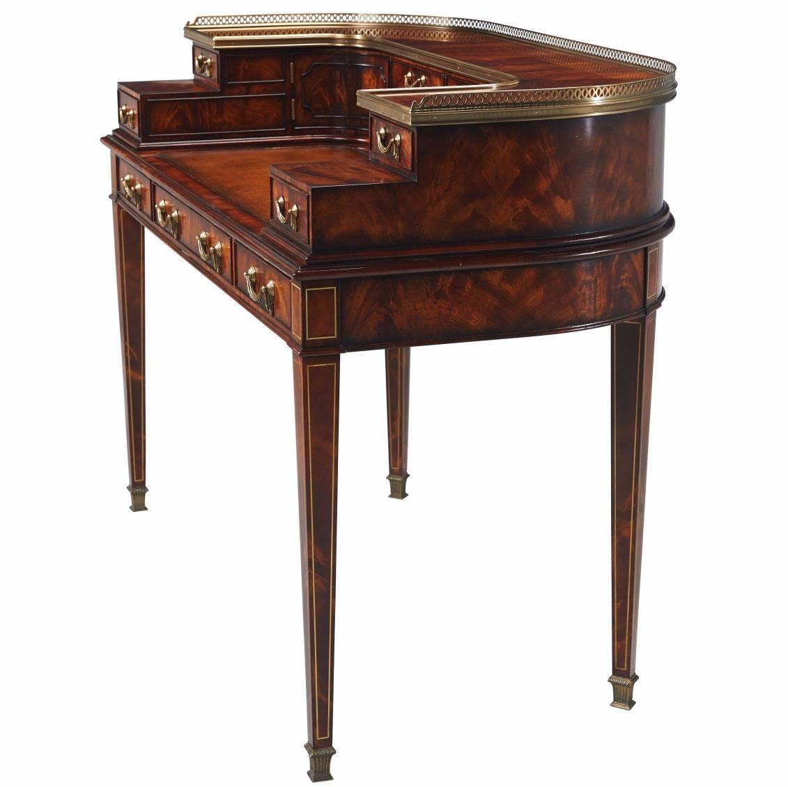Regency style Carlton desk in finest crotch mahogany veneers with 11 oak lined drawers and two shaped cupboards. Solid brass handles and gallery and hand tooled hide writing surface.