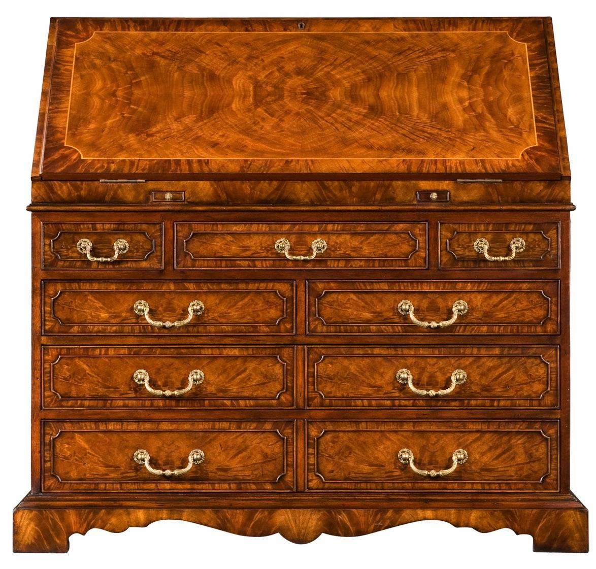 An ingenious mahogany bureau desk in the George III manner. The sloping fall front encloses an elaborately fitted interior of faux books and hidden drawers and cabinets. The staircase gallery interior has suede panelling with a short frieze drawer