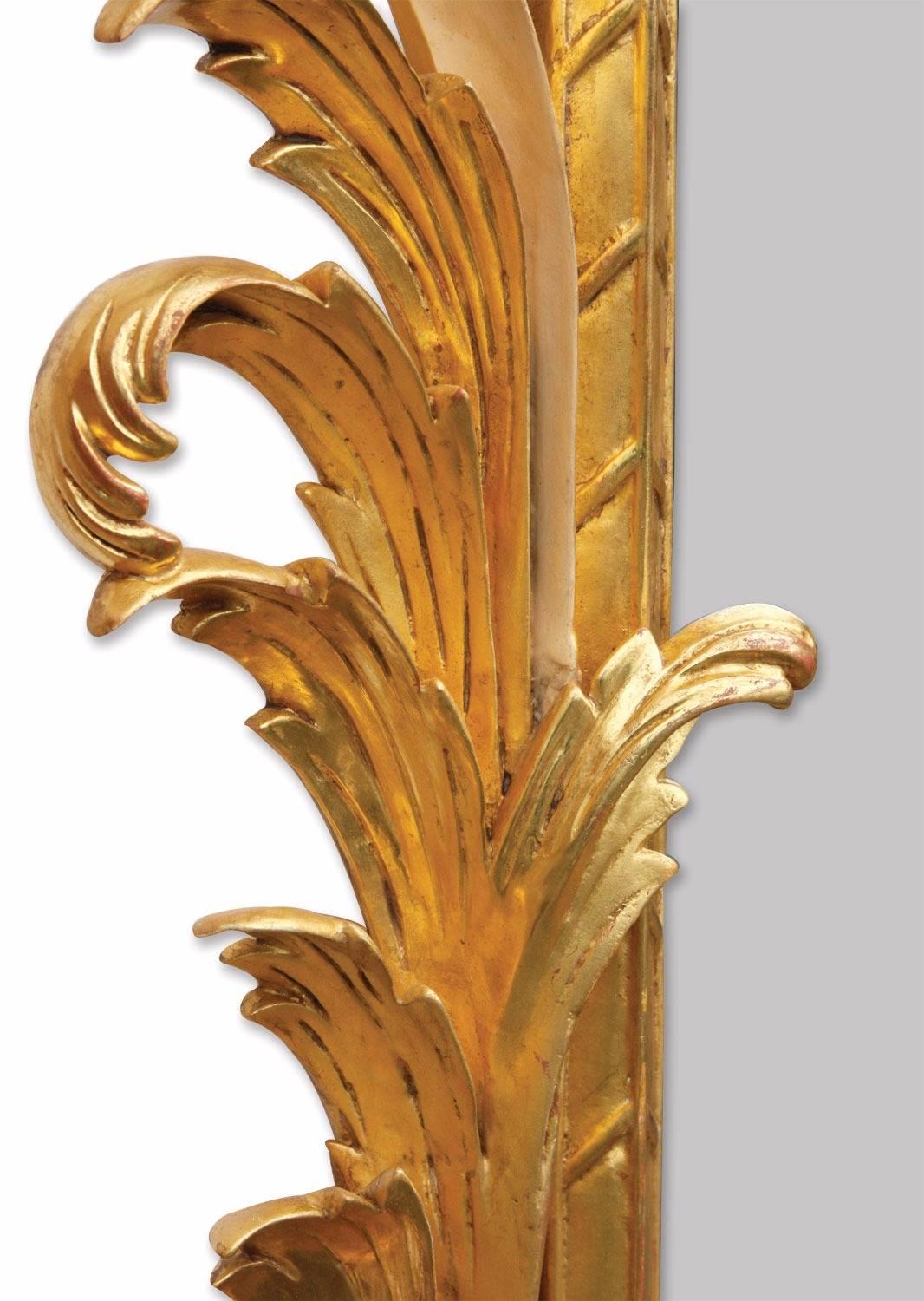 A giltwood wall mirror after an original from our archives originating from Biggs of Maidenhead run by our family. Entirely hand-carved in mahogany and water gilded in 23¾ carat gold leaf, toned with a ‘bright and matte’ effect, the highlighted