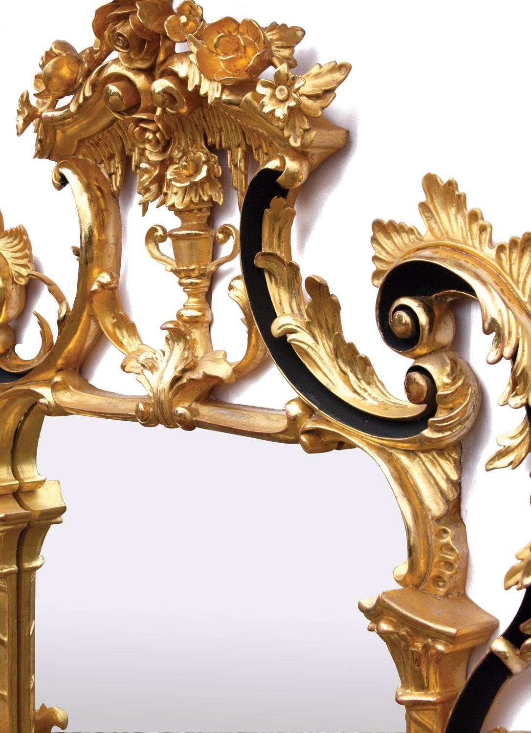 A giltwood wall mirror after an original from our archives originating from Biggs of Maidenhead, run by our family. Entirely hand-carved in mahogany and water gilded in 23¾-carat gold leaf, toned with a ‘bright and matte’ effect, the highlighted