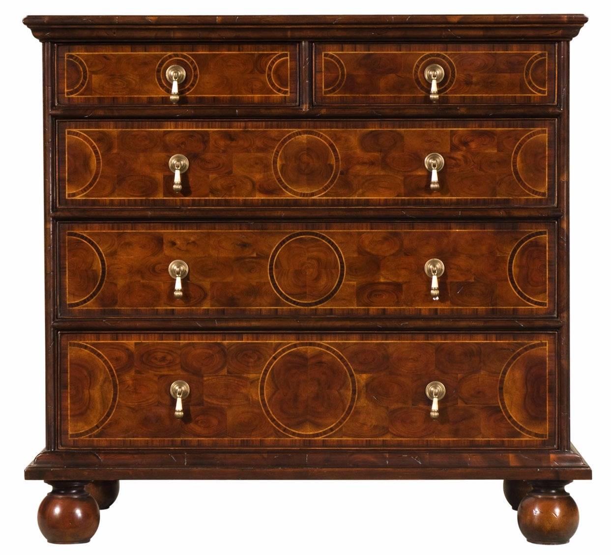 An oyster veneered chest of drawers, the rectangular parquetry inlaid top and sides with cross grain moulding, above two short and three long graduated drawers with brass and bone drop handles, on bun feet. The original William and Mary.