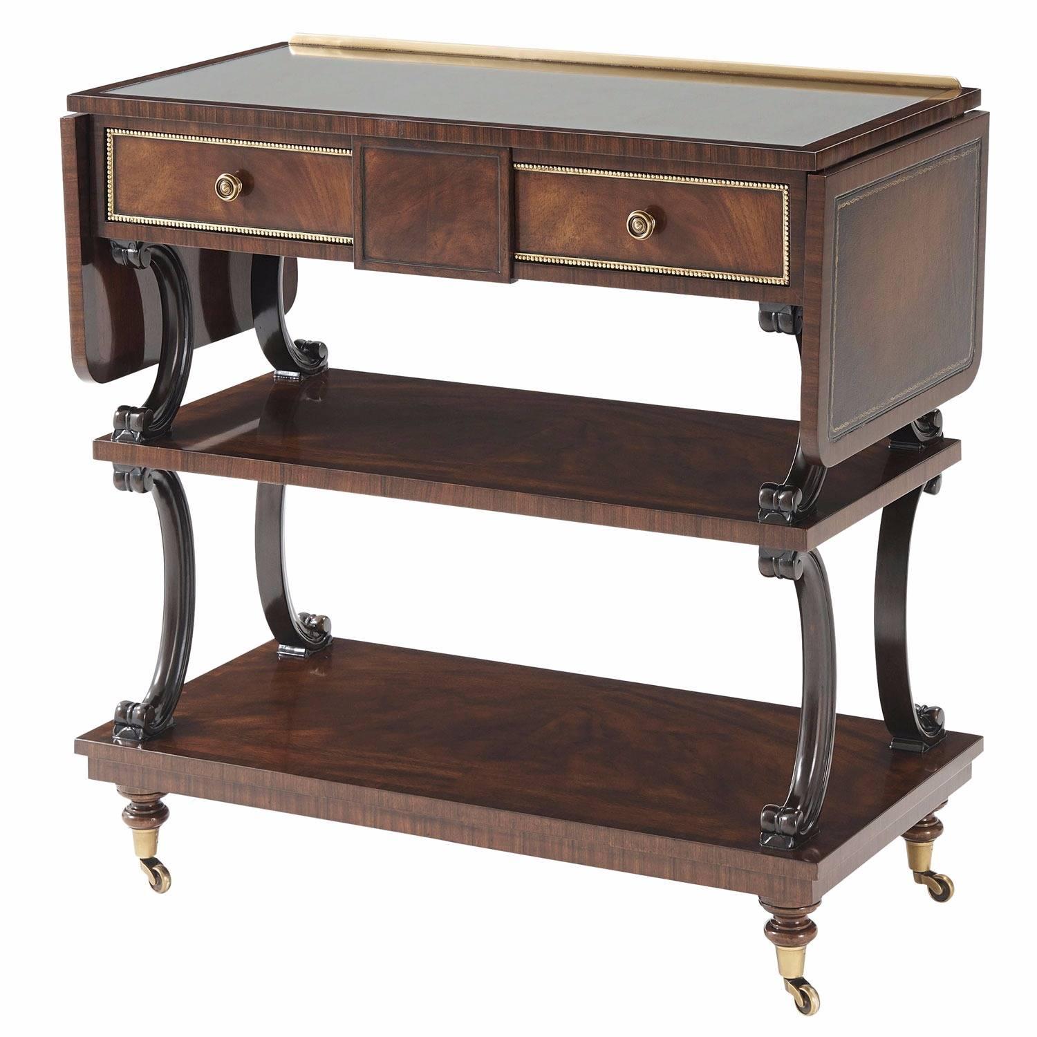 A swirl mahogany veneered and rosewood banded bar cart, the églomisé top with two hand stained leather inlaid drop leaves, the frieze with two gilt beaded drawers, on ebonised mahogany 'C' scroll supports between two undertiers, on turned legs with