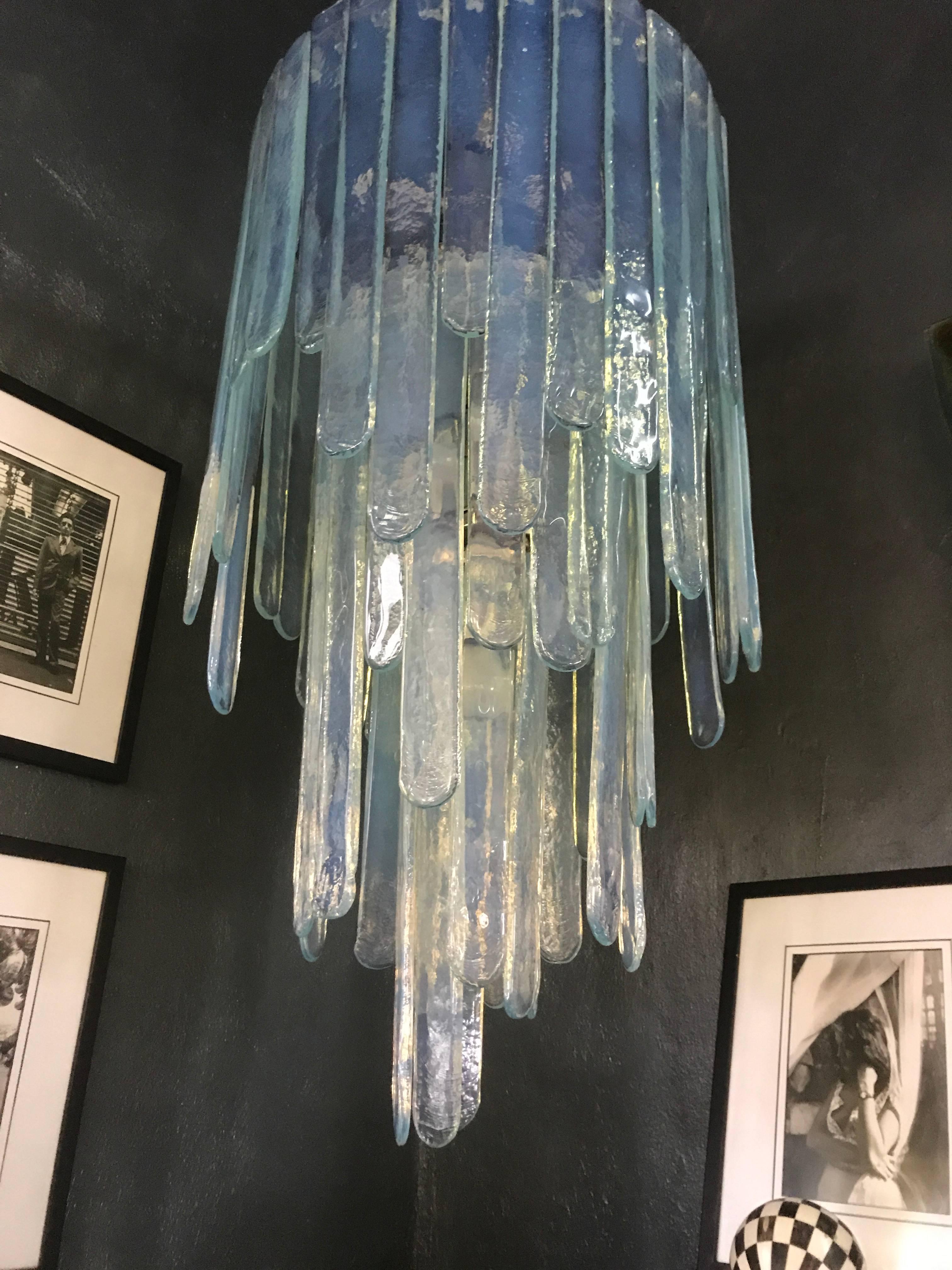 Lustre de style Mid-Century Modern de Carlo Nason pour Mazzega dans une teinte bleue opalescente, composé de trois étages de lames de verre. Ce lustre est complet car il n'y a pas un pouce d'espace libre là où les lames sont suspendues. Il mesure