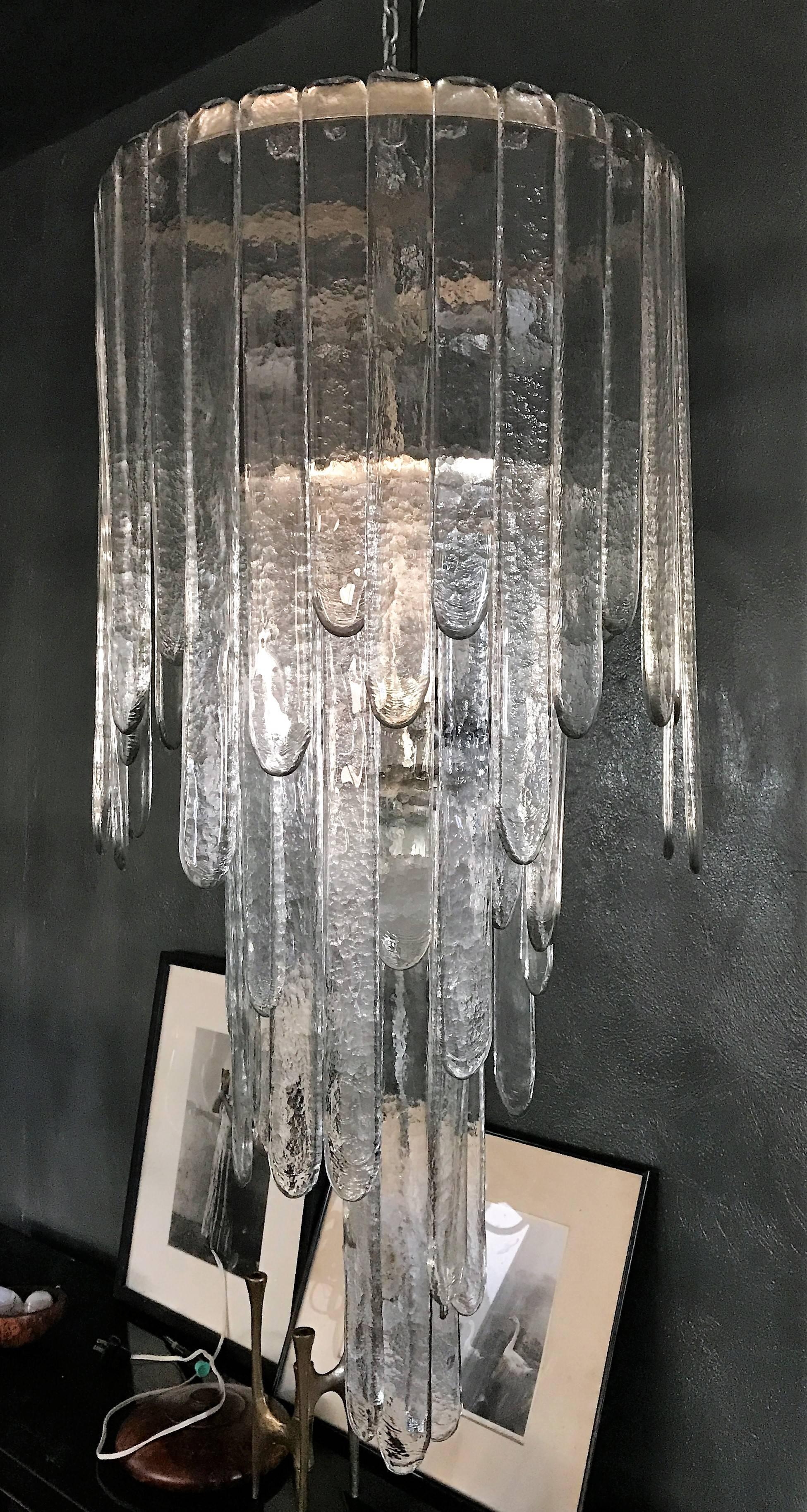 Mid-Century Modern chandelier by Carlo Nason for Mazzega consisting of three stages of clear glass blades. This chandelier is complete as there is not one inch of space free where the blades hang from. It measures 114 cm tall in its current