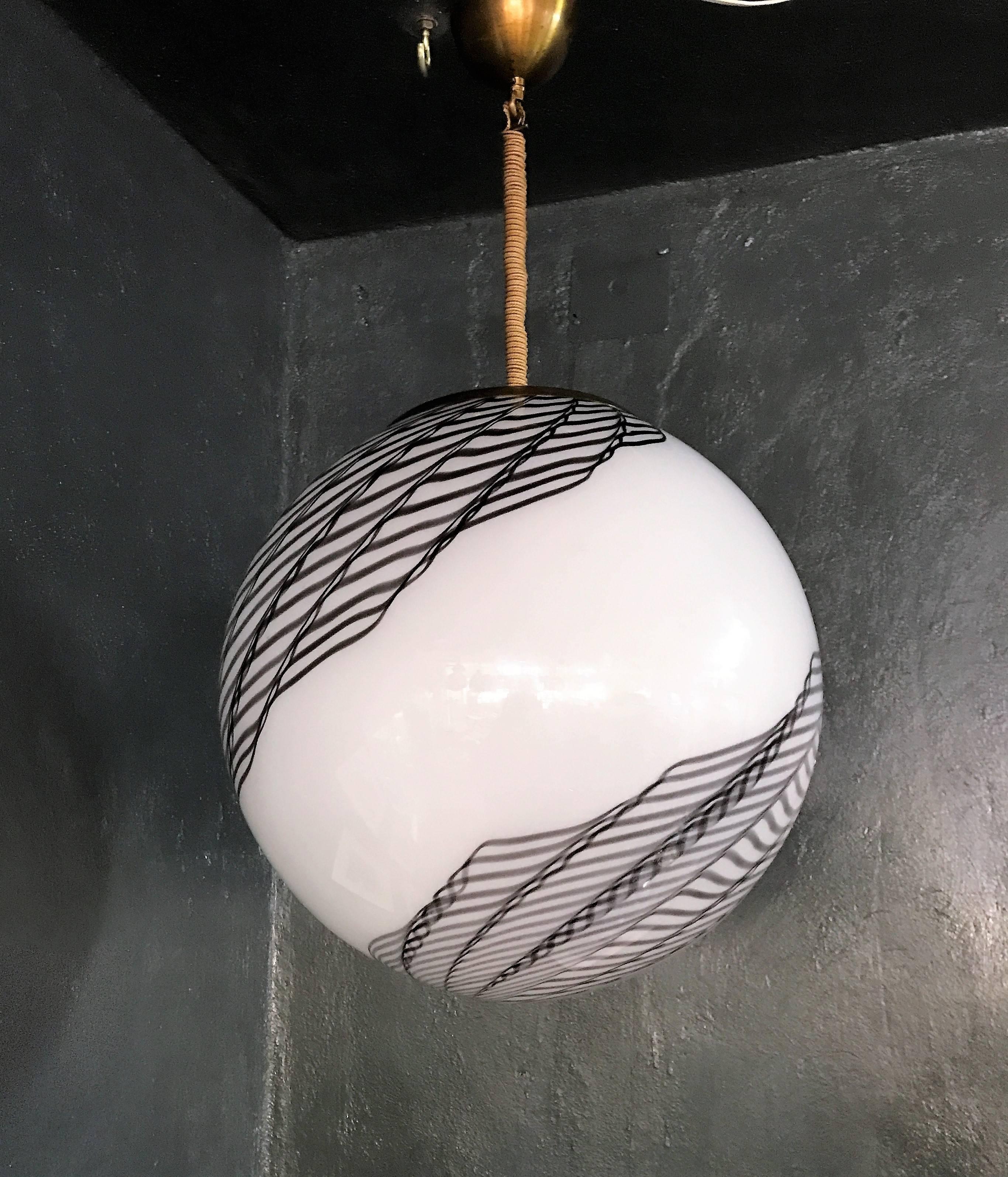 Beautiful and large pendant light in white and black handblown Murano glass, attributed to Venini, circa 1970.