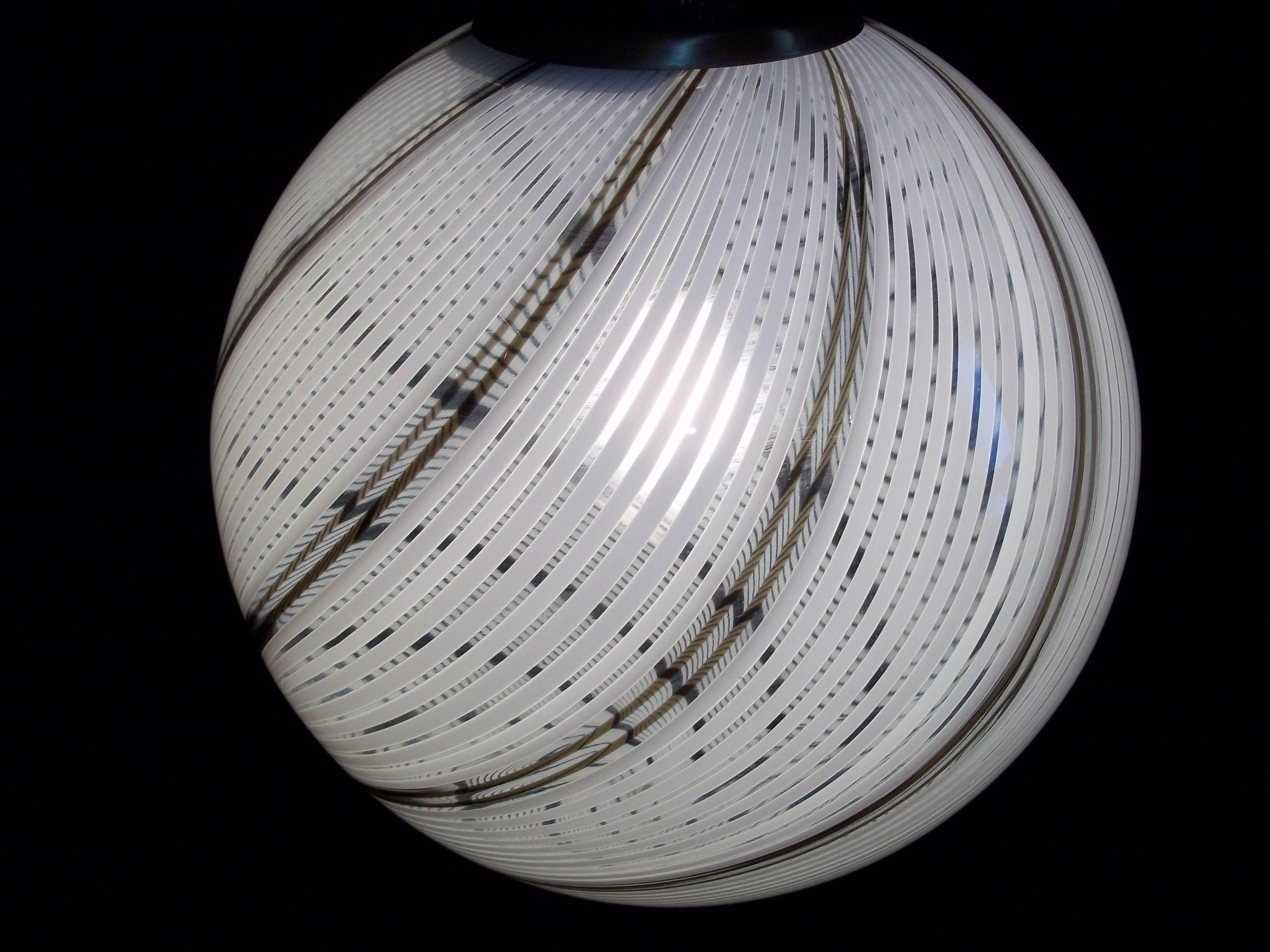 Bellissima sfera a sospensione in vetro di Murano soffiato a mano bianco, nero e trasparente, attribuita a Venini, circa 1970.
Misure: Il diametro è di 30 cm.

 